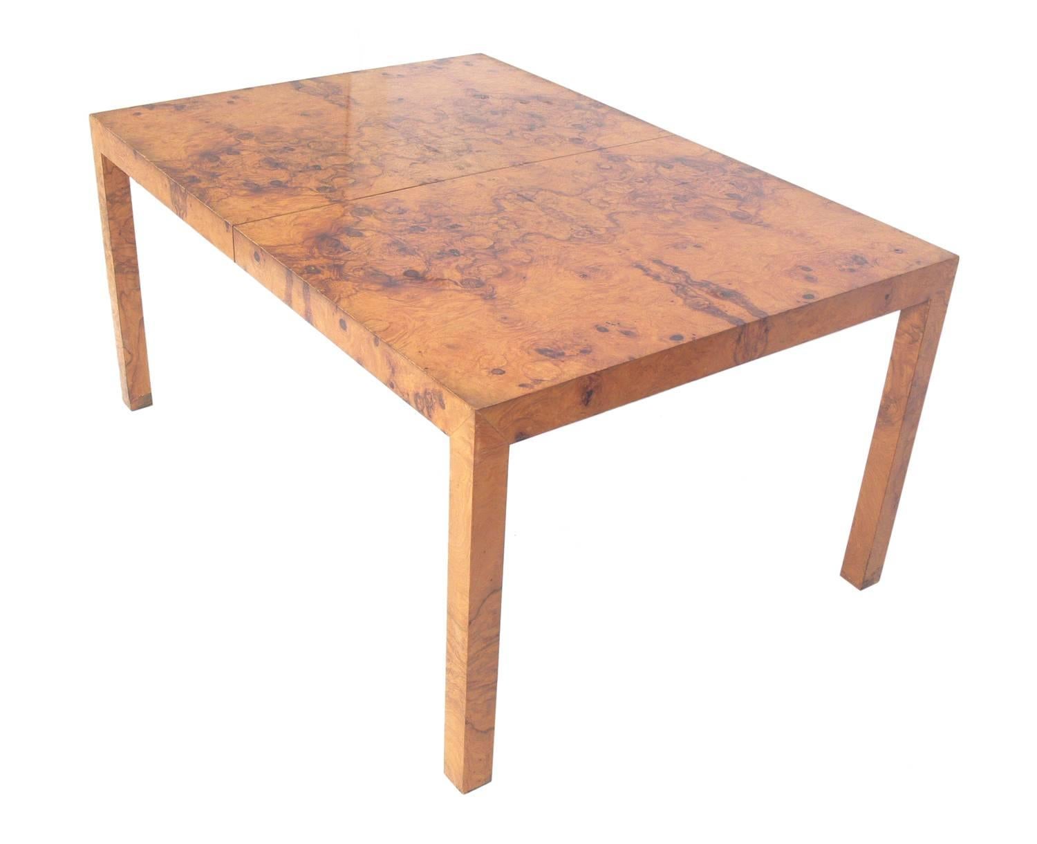 Clean lined burl wood dining table, designed by Milo Baughman, American, circa 1960s. With all three leaves installed, the tables measures an impressive 90