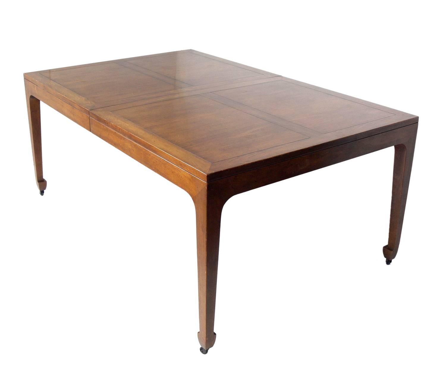 Asian influenced dining table, designed by Michael Taylor for Baker, circa 1960s. Retains Baker tag underneath. This table is a versatile size and expands from 68.25 width to an impressive 122.25" width with all three leaves installed. It can