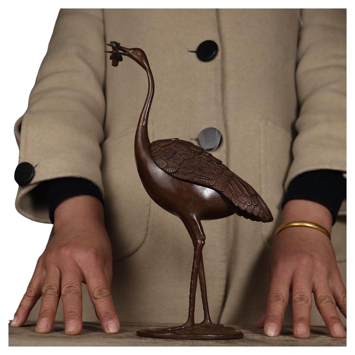 This Old Chinese Bronze Crane Sculpture Burner is a stunning work of traditional artistry and cultural symbolism. Crafted from solid bronze, this exquisite burner features an intricately detailed crane sculpture, a revered symbol of longevity,