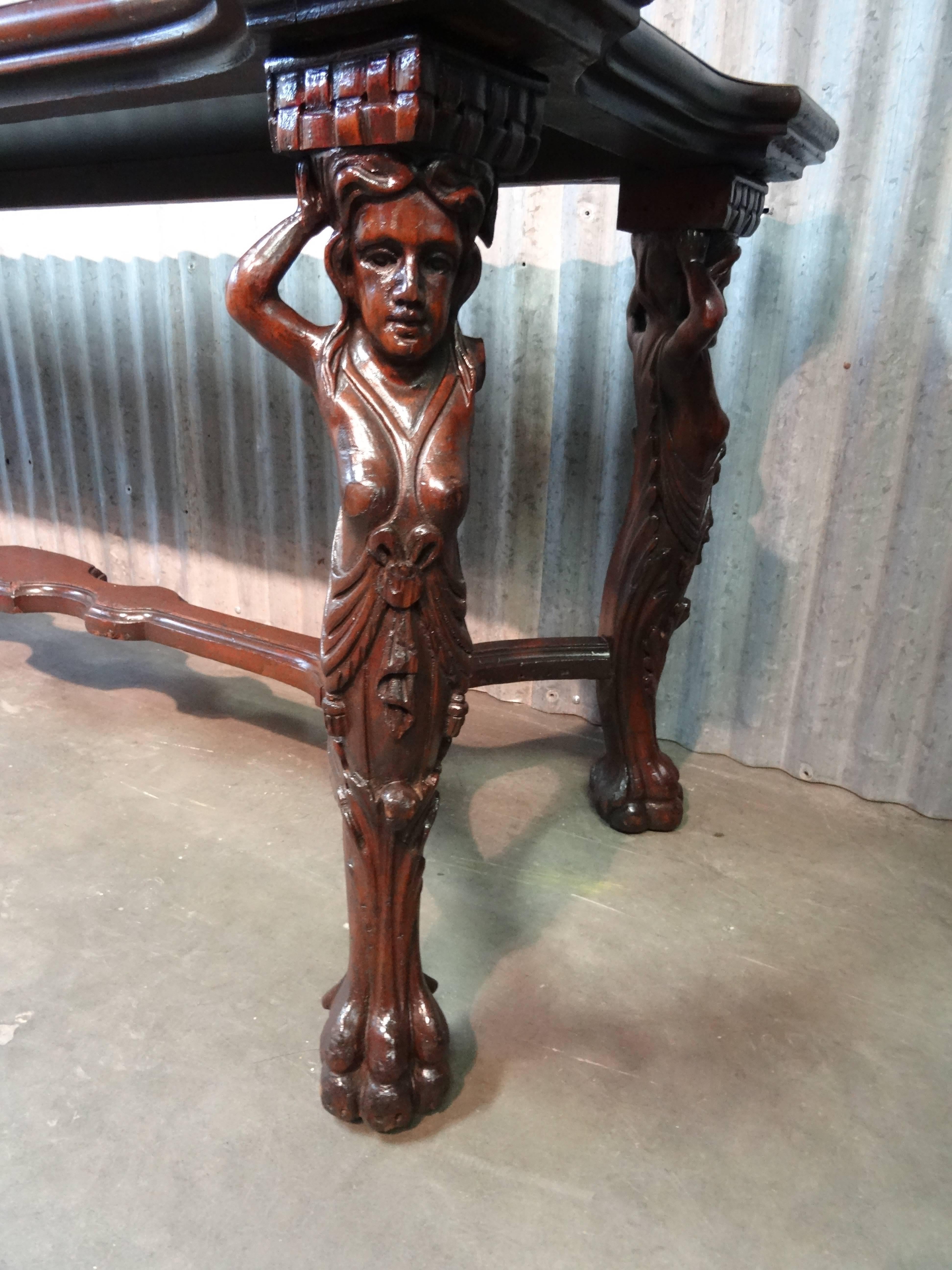 Hand-carved, walnut, nymph table with added industrial flare.  Could be a 19th century piece, early 20th century for sure.  This table beams with dings, dents and bruises of the past, but still very charming.  The top was destroyed, but originally