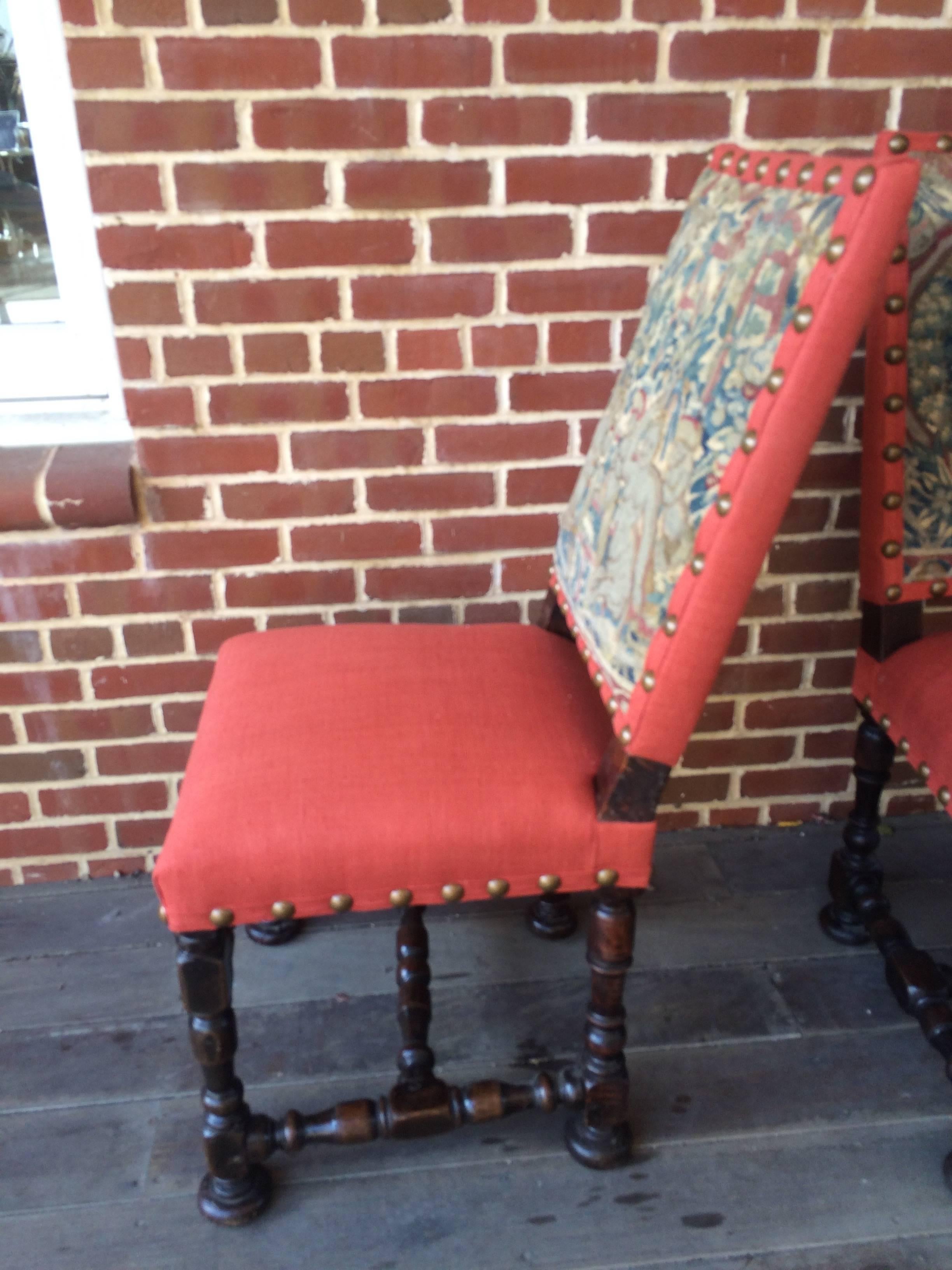 A rare pair of 17th century Louis XIV period side chairs. Intricately turned legs and cross stretchers made of European brown oak with a deep patination and rich lustrous color. Retaining the original period needlepoint tapestry on the backs with