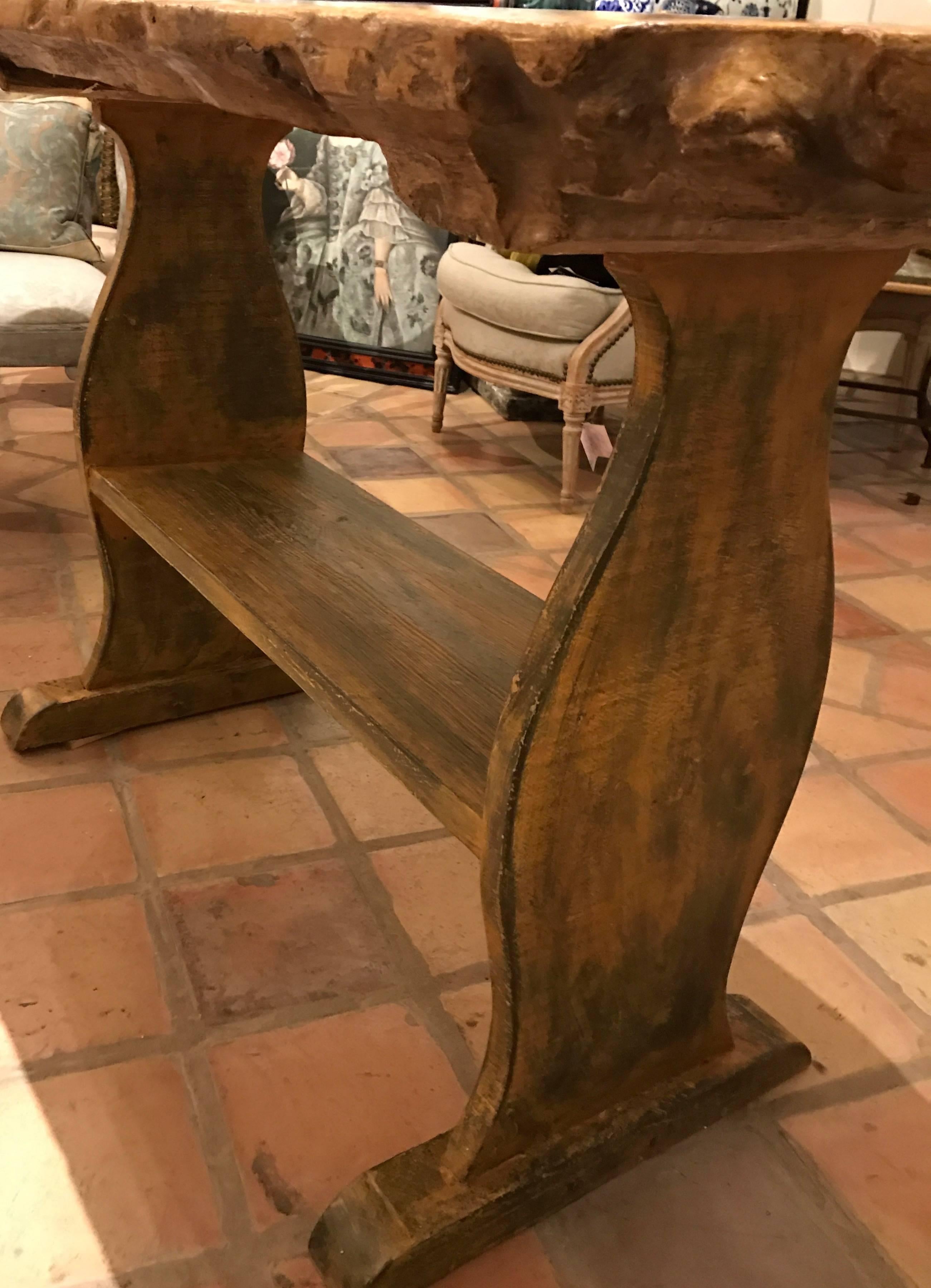 Early 19th century rustic “Basque” oval trestle table or console. Top made of a single very thick highly figured piece of burled ash with a wonderful color and rich patination. The simple trestle base with shelf made of pine retaining an old painted