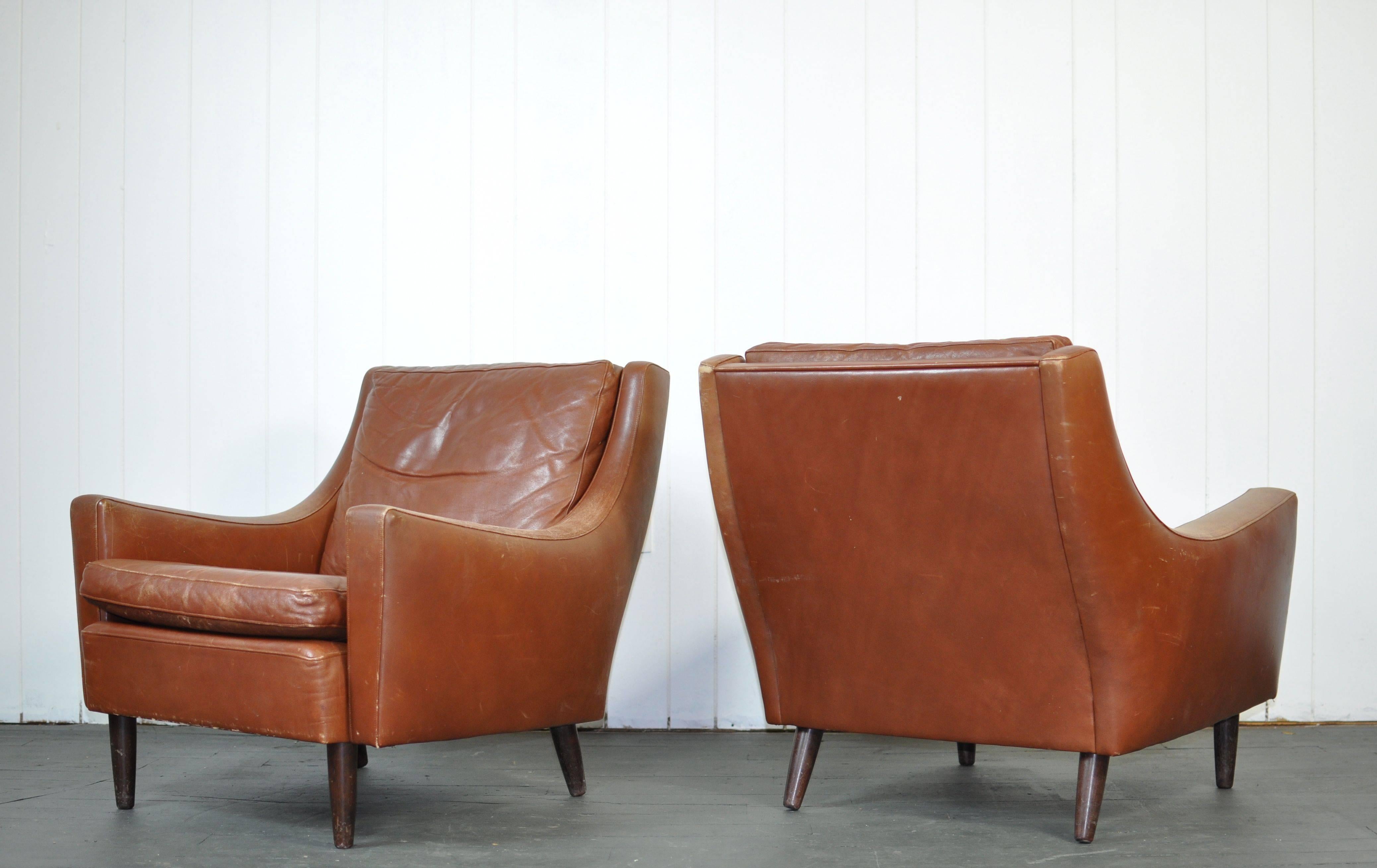 Pair of Danish leather lounge chairs with teak legs. 

Please inquire regarding trade pricing.