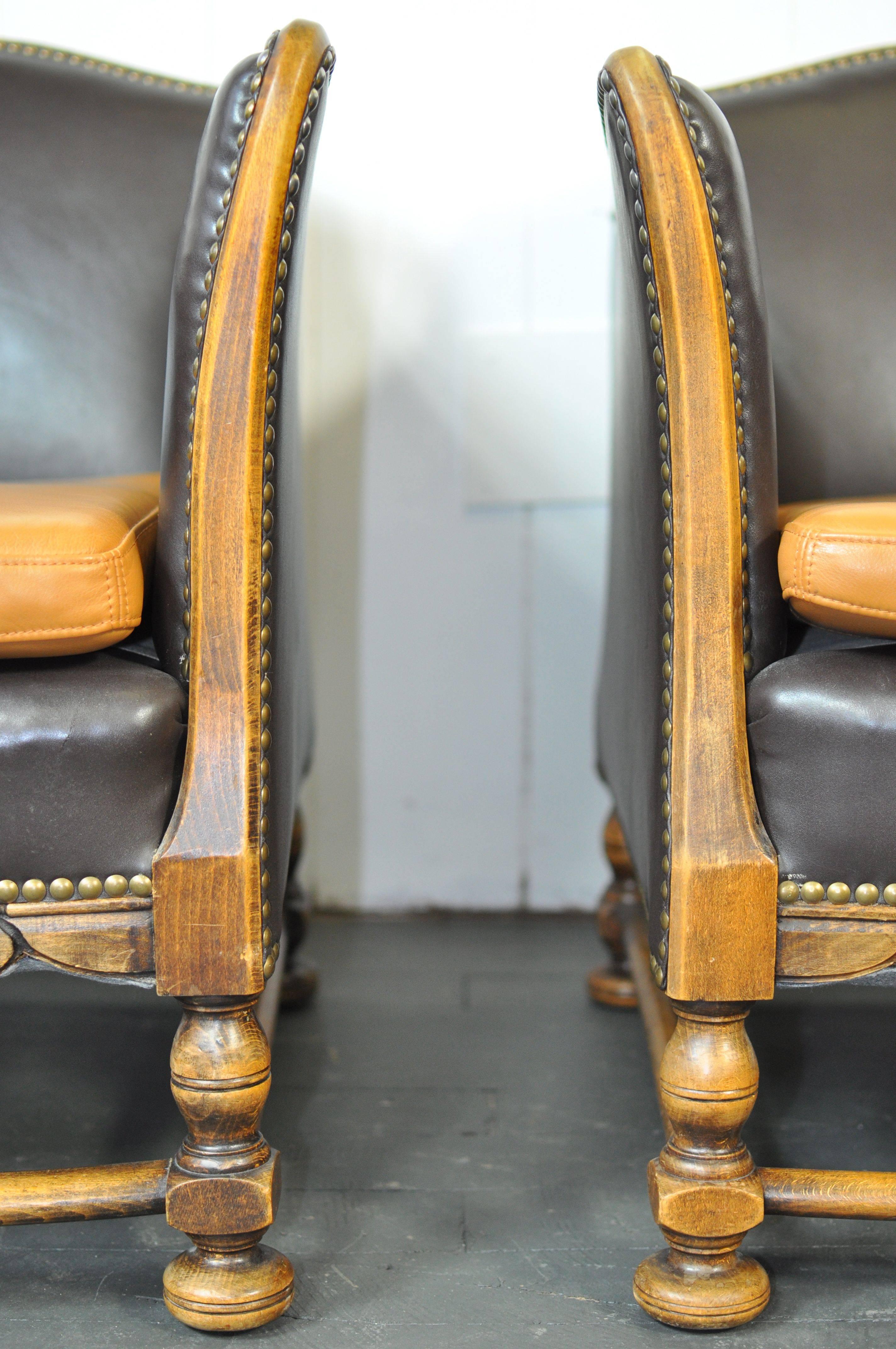 1920s carved Swedish lounge chairs. Recently upholstered in a very dark brown leather with contrasting leather seat cushion.