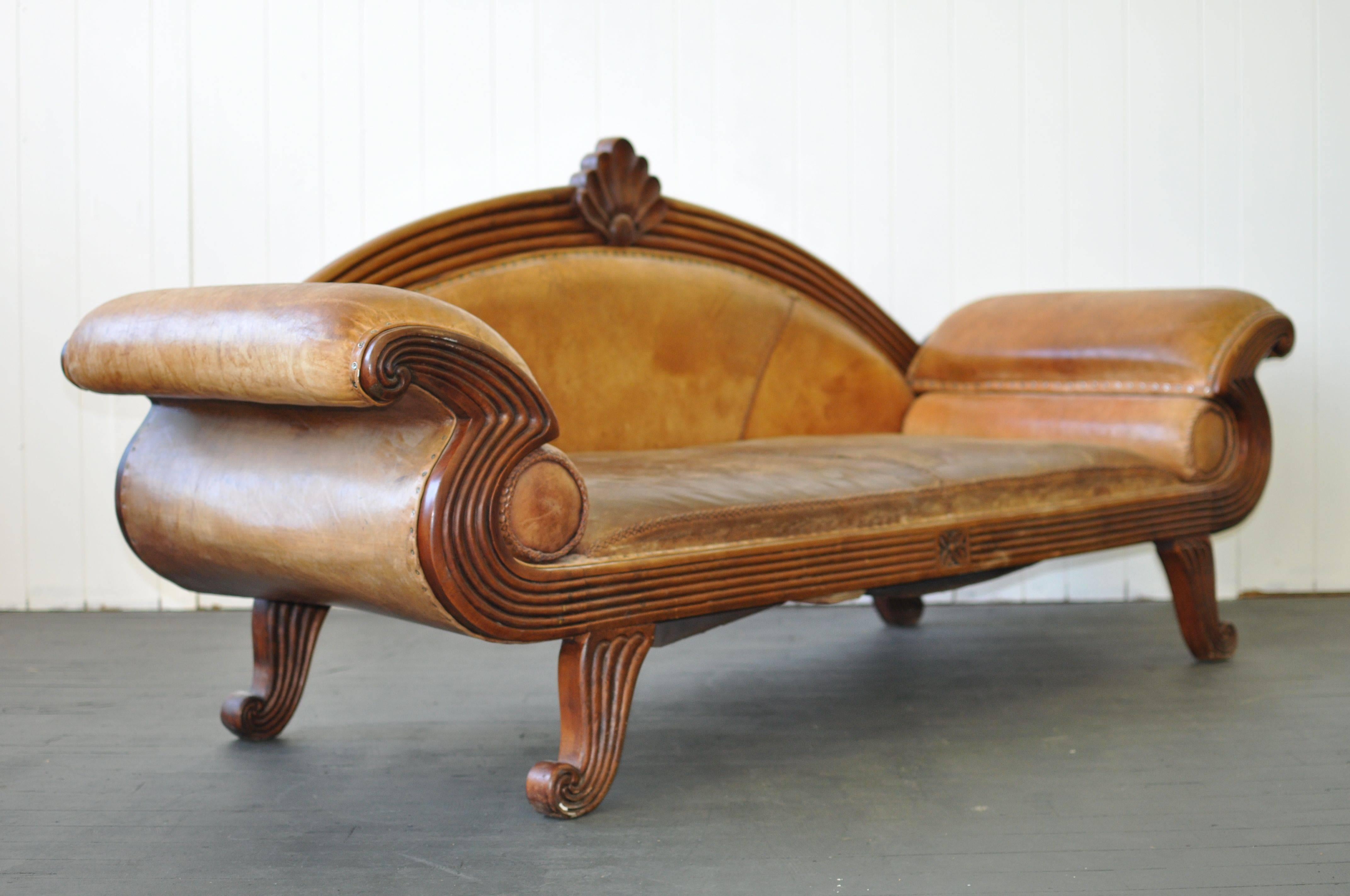 Early 20th century European leather sofa with original distressed hand-stitched leather. Carved Mahogany frame.