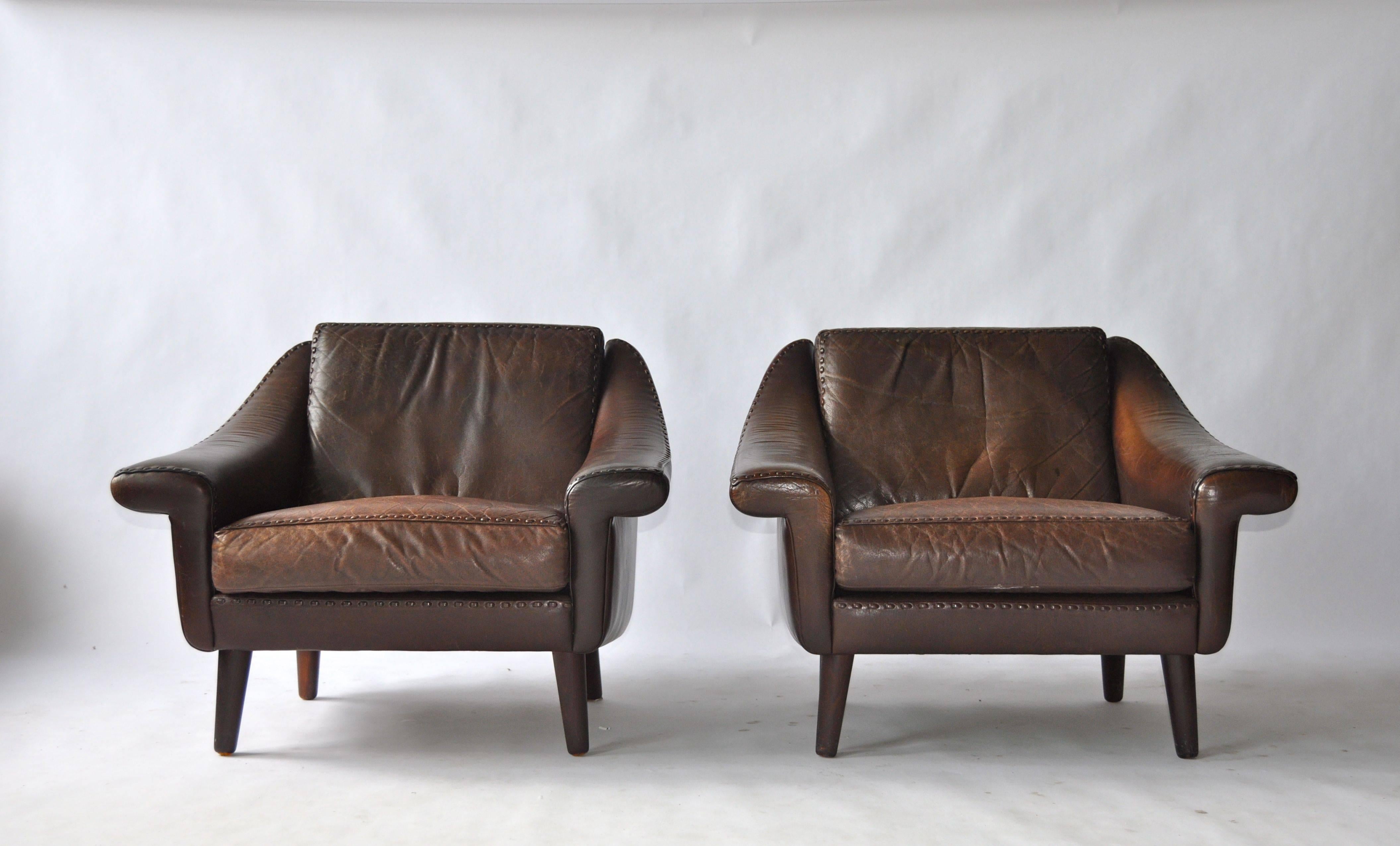 Pair of Aage Christiansen Danish leather lounge chairs. Original leather with great patina. Stained teak legs.
