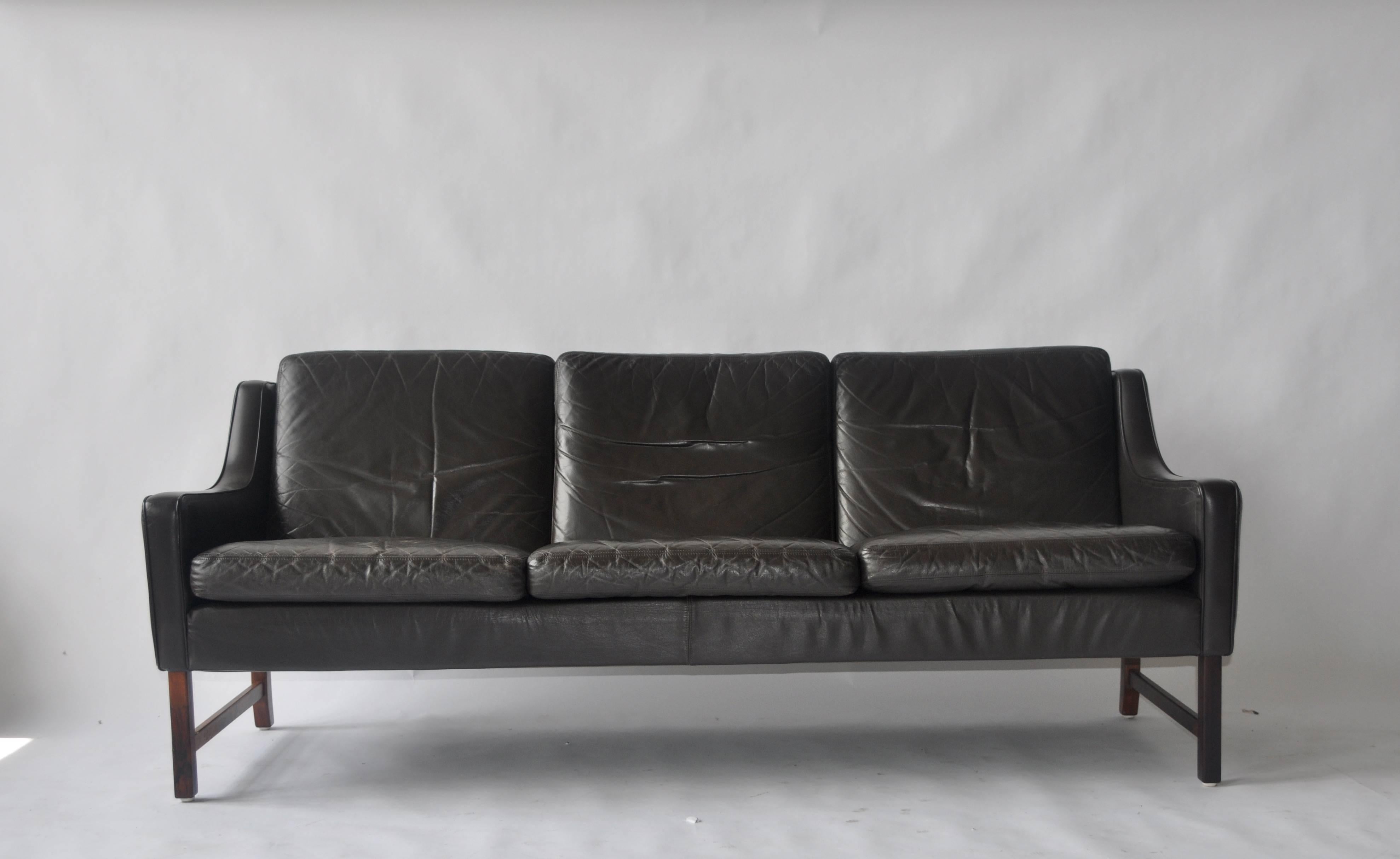Fredrik Kayser leather and rosewood sofa.
Dark brown leather. Matching chairs available.