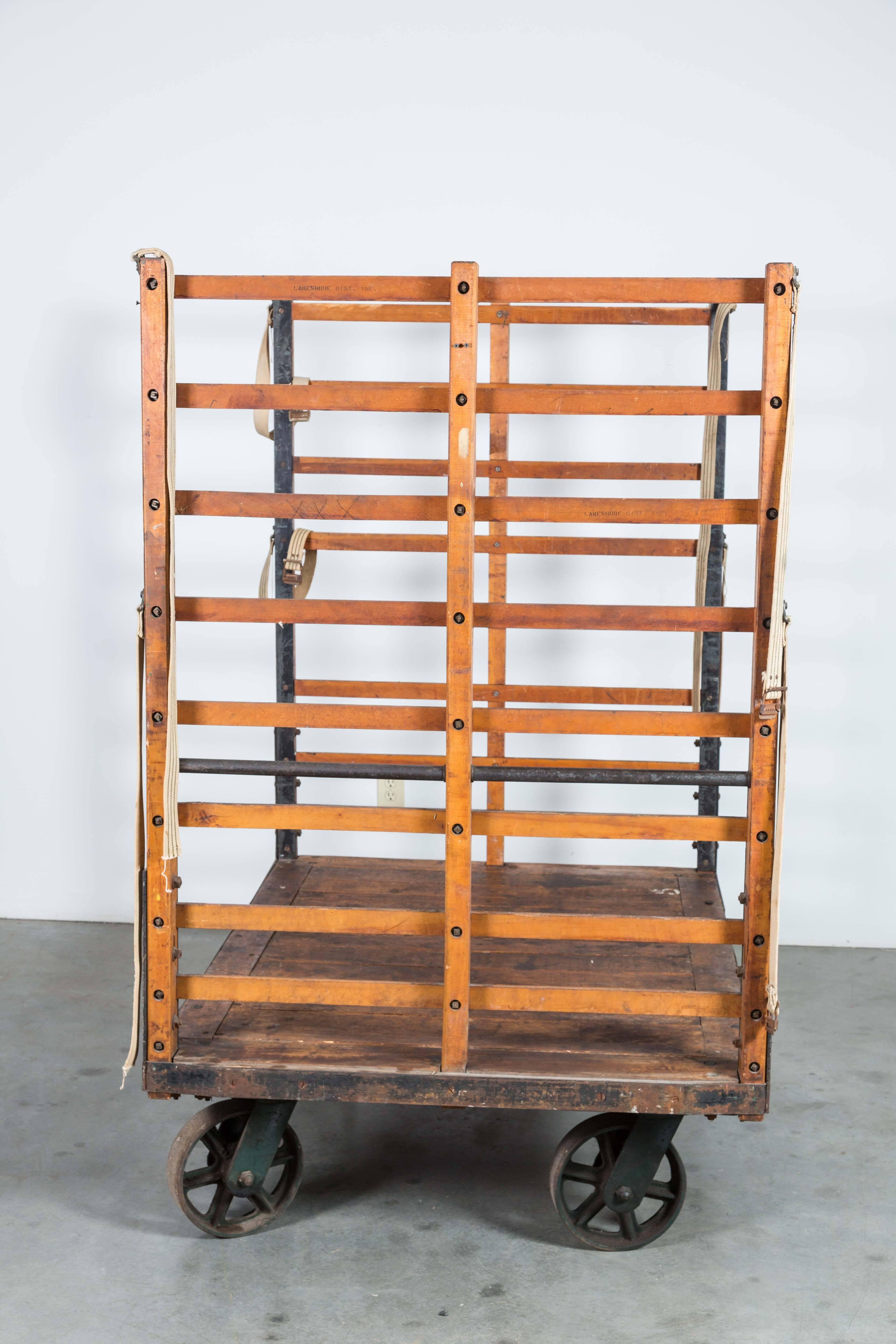 Late 19th century substantial luggage cart from a Midwestern United States train station. Cart moves on four cast iron casters. Wood slats with riveted fabric straps. Stenciled with cart numbers and train station info. Found at Union Station in