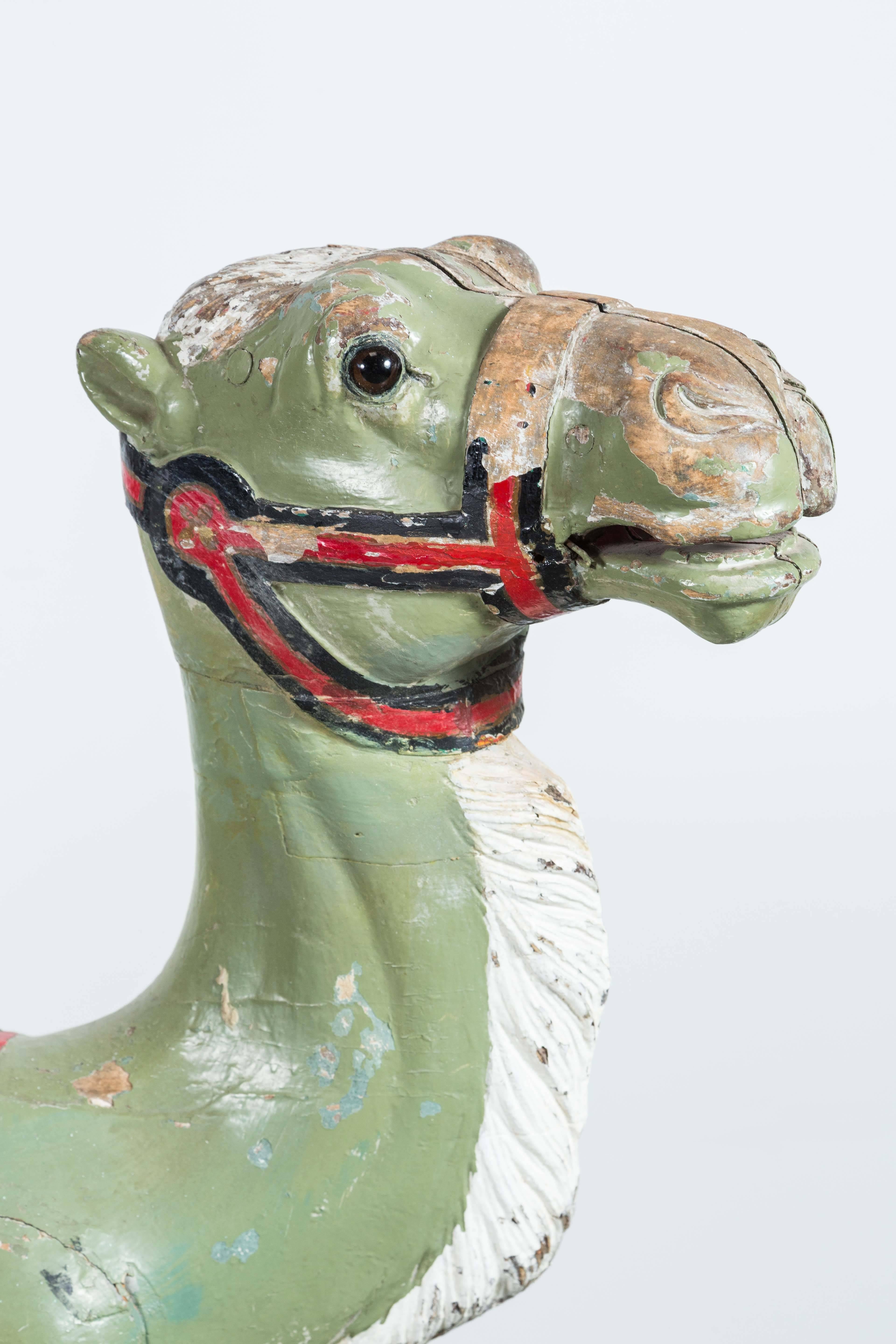 Expertly carved late 19th century carousel camel with glass eyes and original park paint surface. Professional restoration to feet and neck.