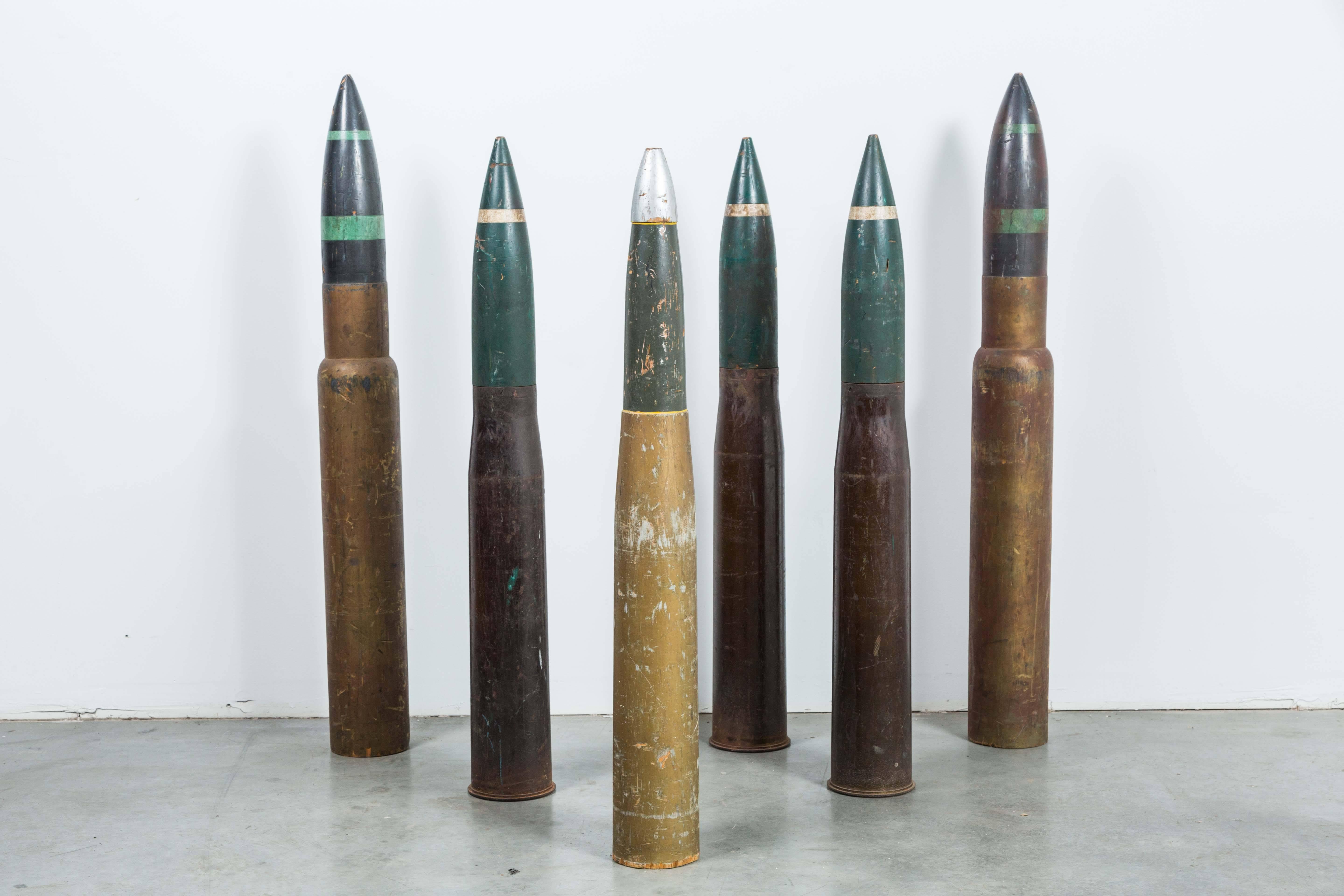 Collection of six wood and iron practice artillery shells found in the California desert. Three of the six have full-metal jacket casings, in which a legible portion ont he bottom of each reads "FOR GUNS M36 M54 M41," "ART