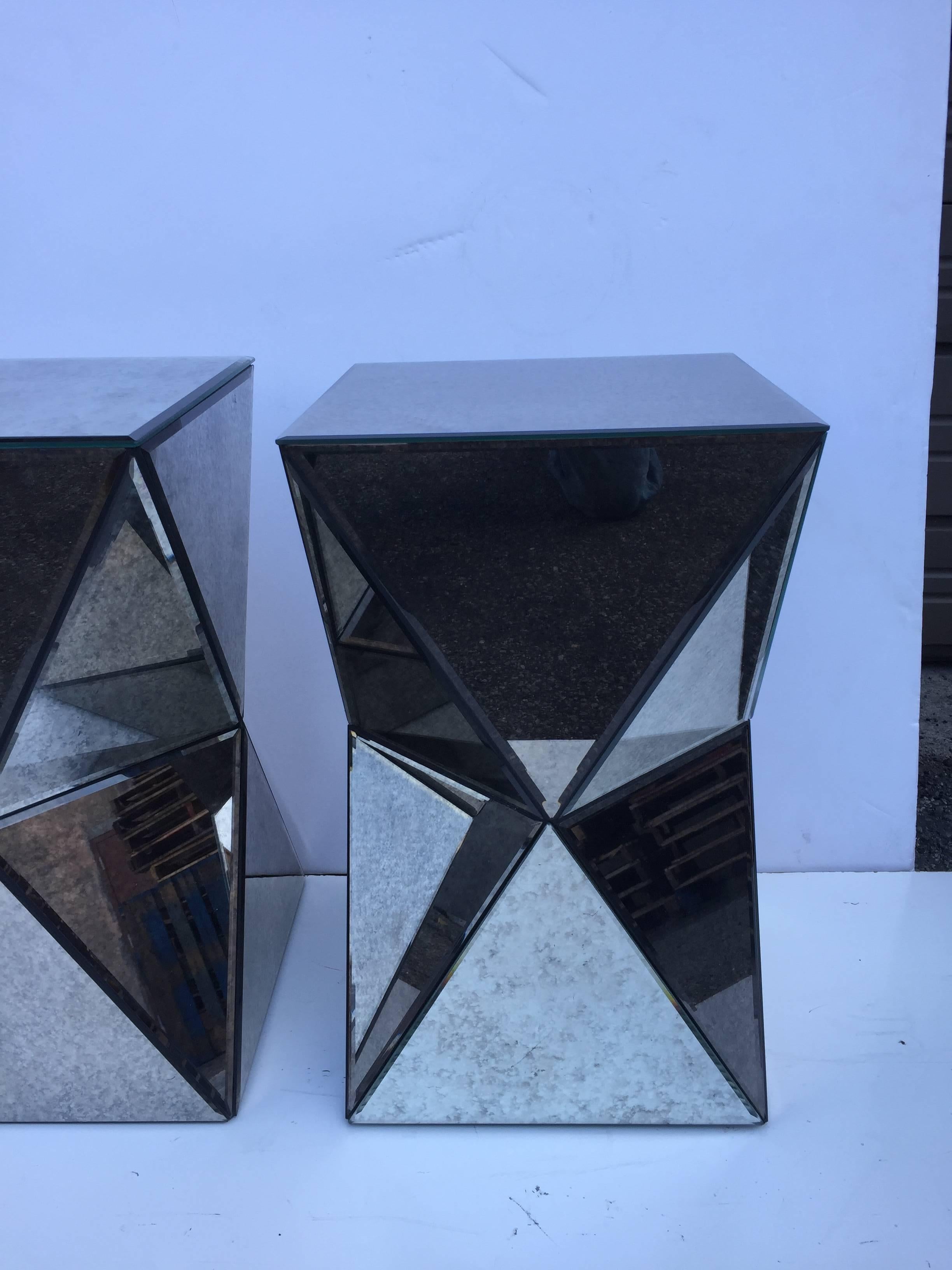 Pair of petite polyhedron small end and or side tables. Antique mirror clad with beveled edges.