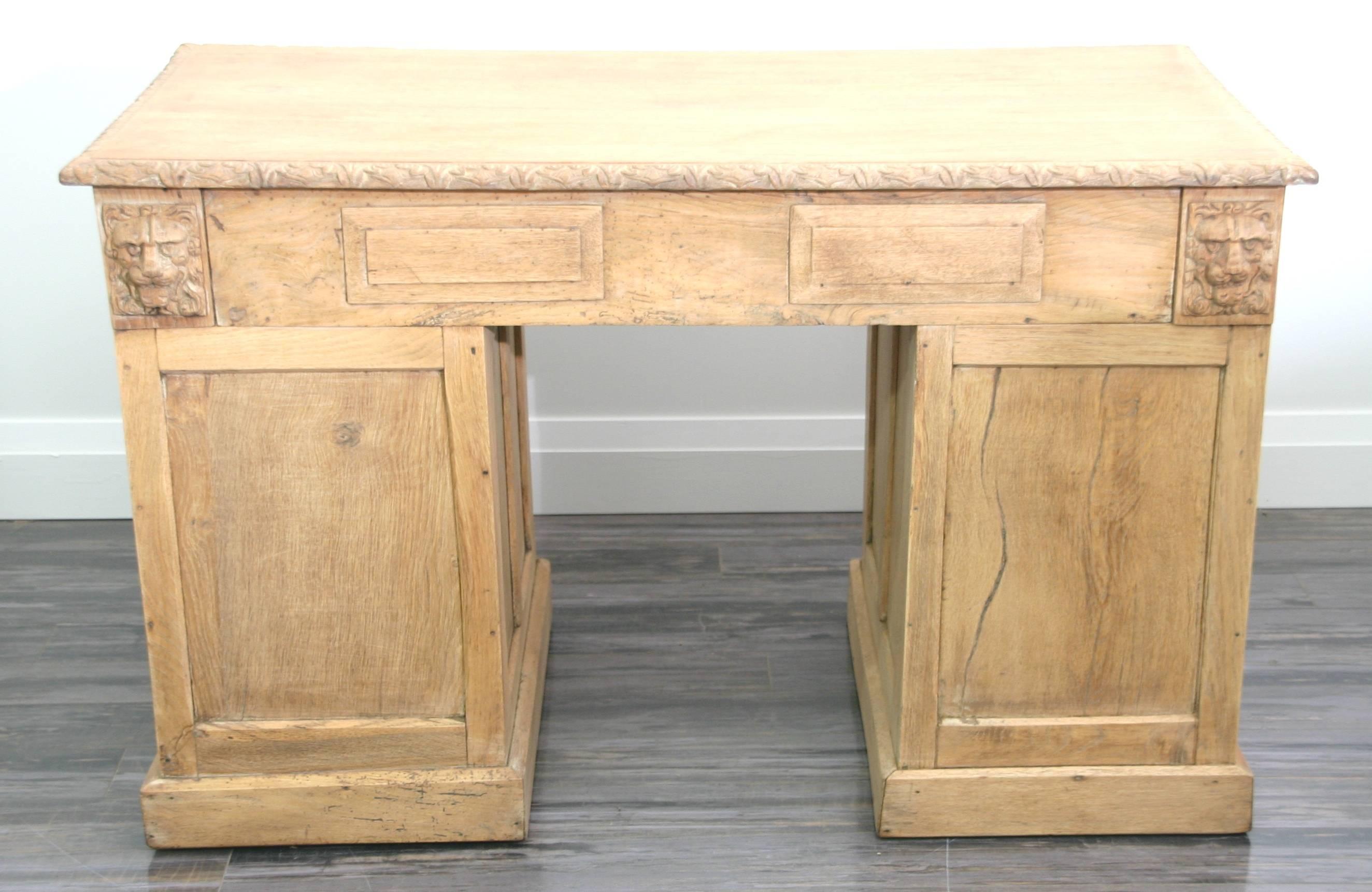 High quality desk made from English brown oak, totally hand-carved with lion heads and relief carved drawers fitted with solid brass drop hardware.