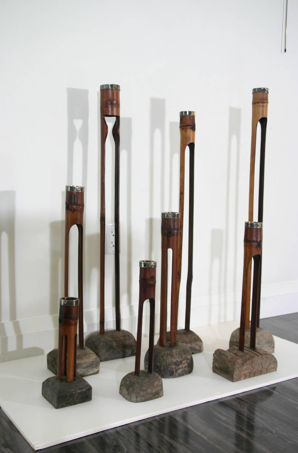 Eight late 19th century Indonesian silver mounted bamboo candlesticks on carved and shaped bases. Various sizes and carved bases. Individually priced. Price and measurements for each individual stick are:

36.25