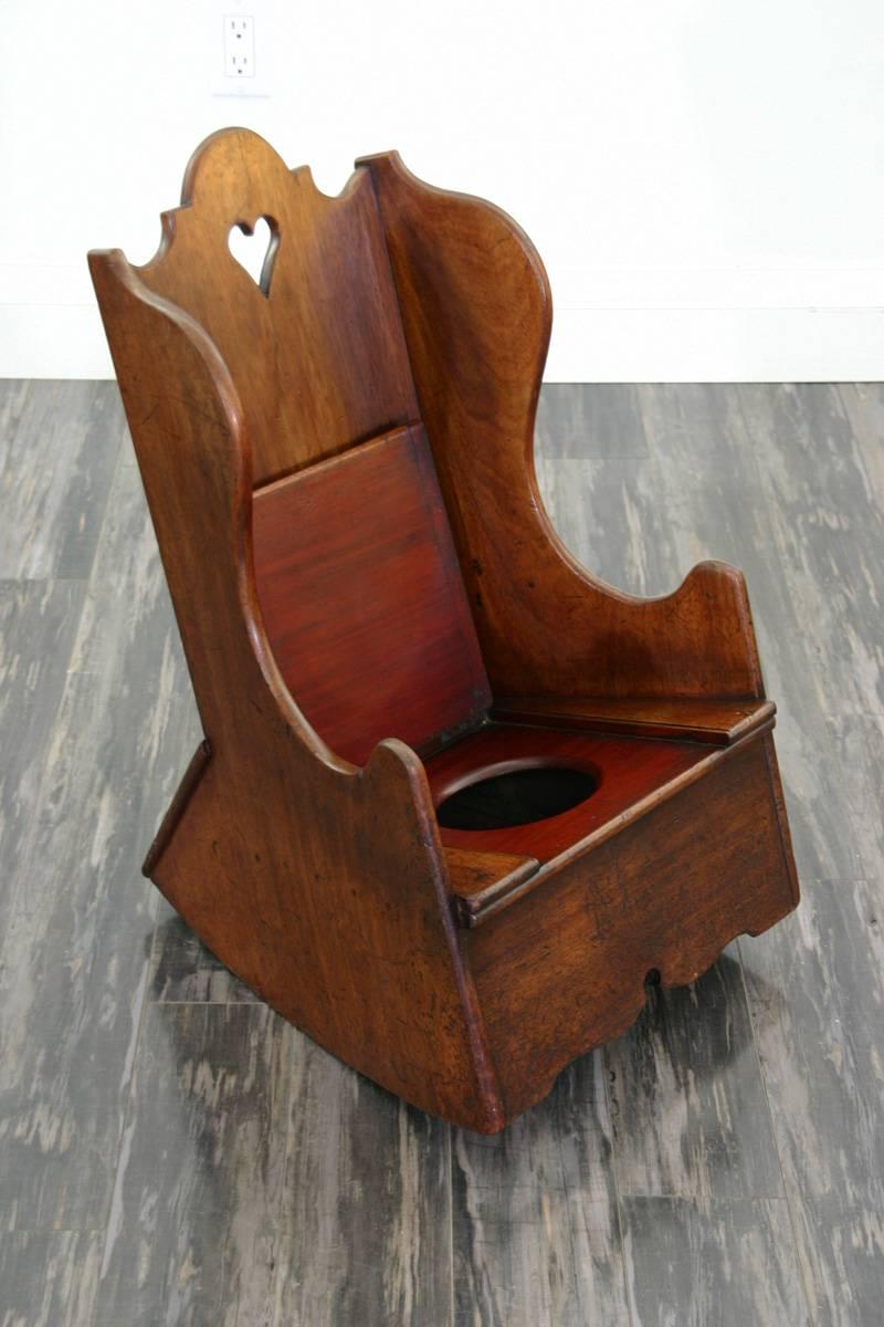 Charming child rocking/commode chair with lift up lid,
(no porcelain bowl.)