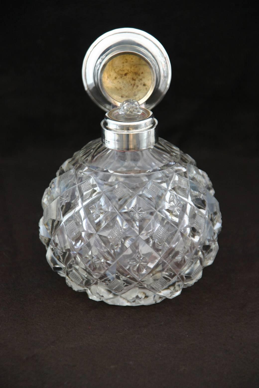 An English, Edwardian cut-glass perfume bottle with silver lid and original stopper. Edwardian silver marks.