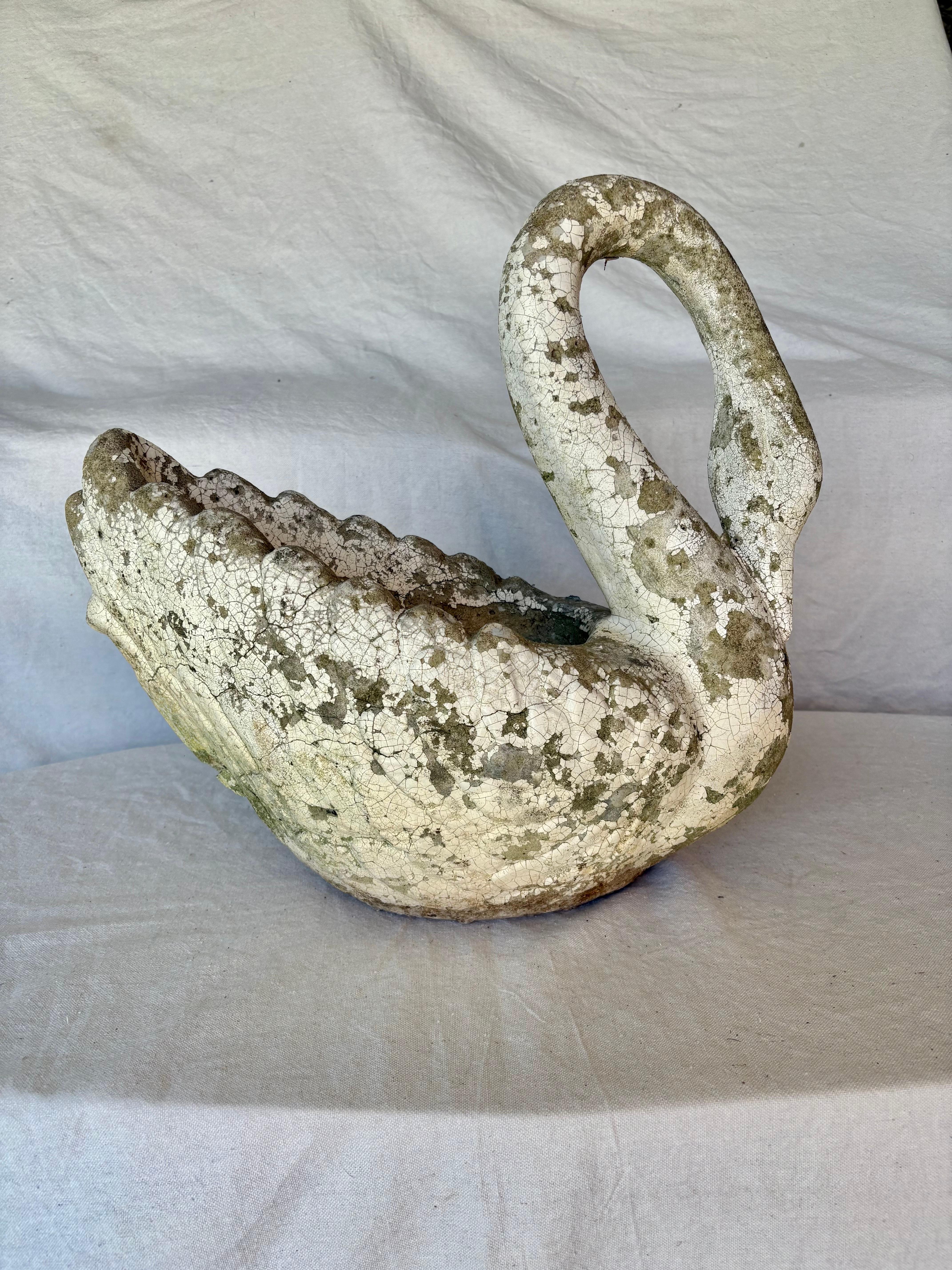 This Early 20th Century Swan Planter was constructed from concrete in the early 1900's. The piece features a naturally aged white patinated patina. The gracefully curved neck of the swan exudes a sense of grace and poise. Crafted with attention to