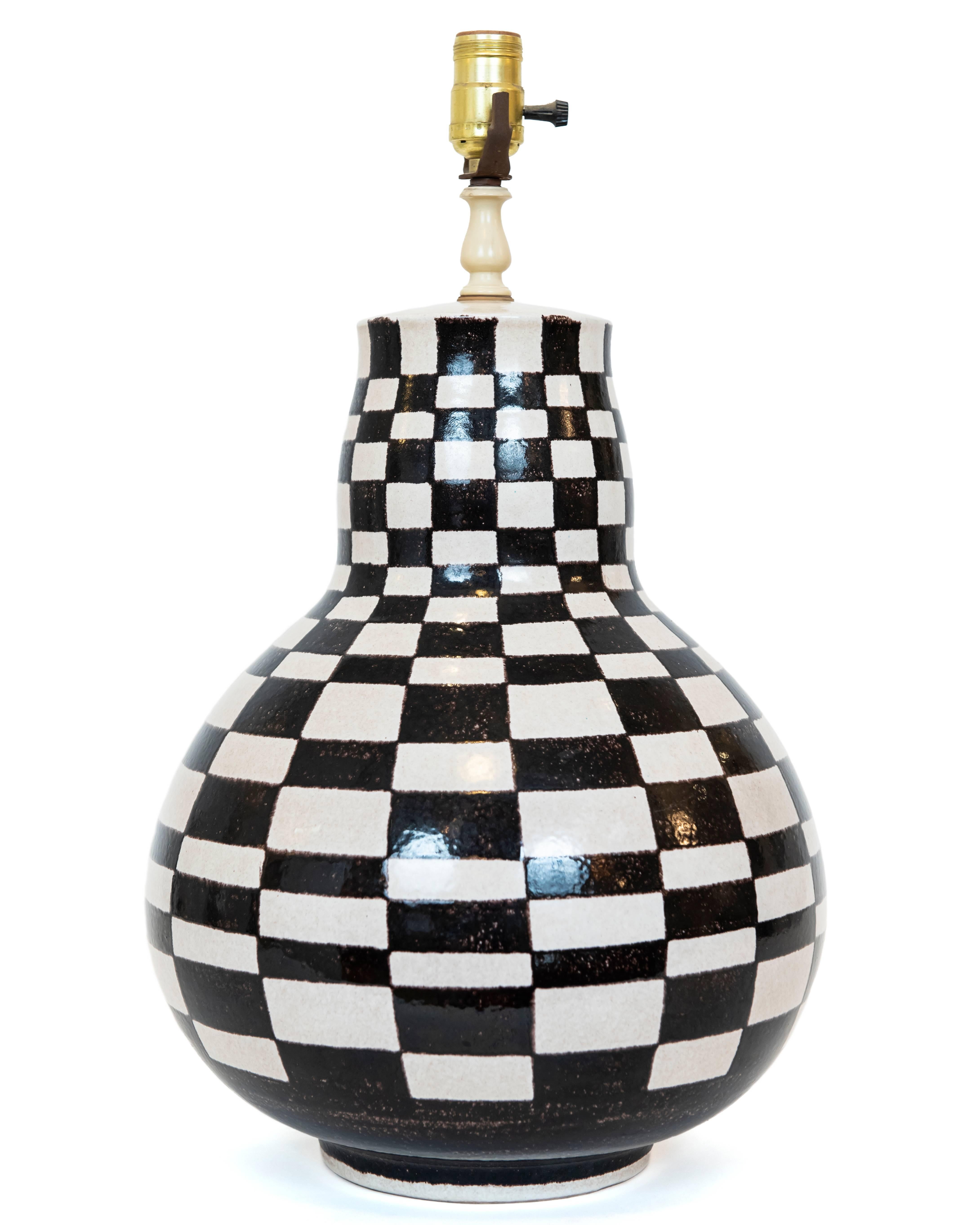 I love the look of this lamp! Black and white checkerboard pattern hand done in Italy over a gourd shaped base. Fun, stylish and unique!
New shade optional. Rewired. Measures: Top of the shade height is 28