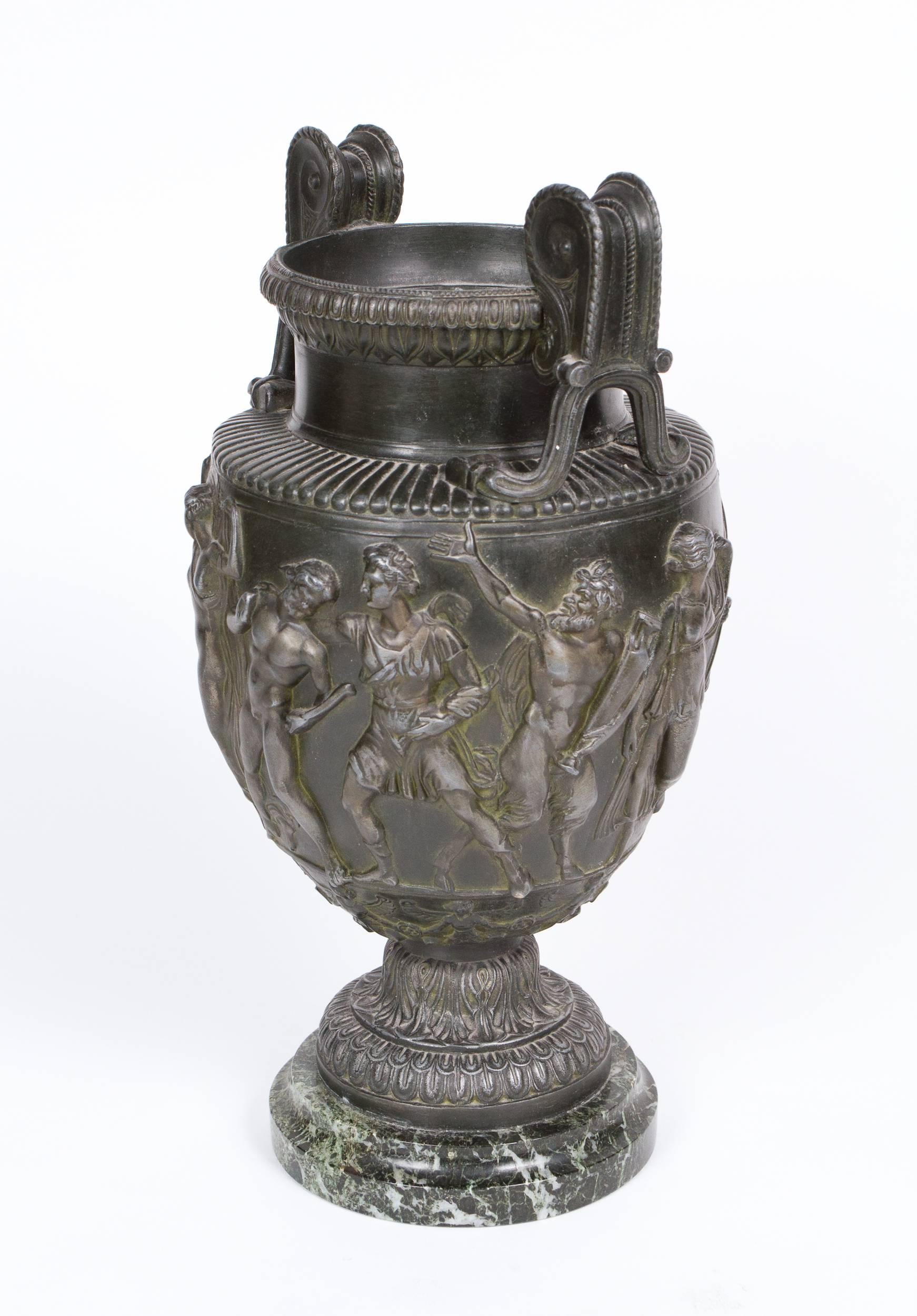 Neoclassical style patinated metal Grand Tour Campana vase featuring a frieze depicting a Bacchanalian procession. Set on an antico verde marble base.