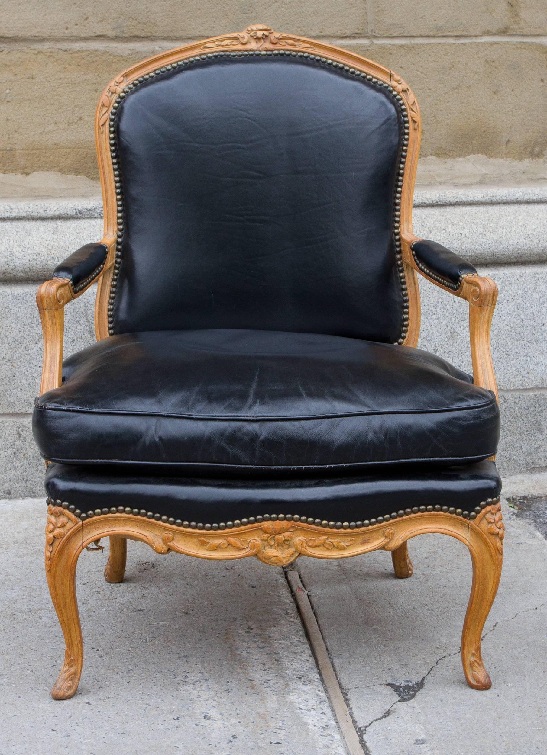 Beautiful pair of carved beechwood Louis XV style armchairs upholstered in black leather.