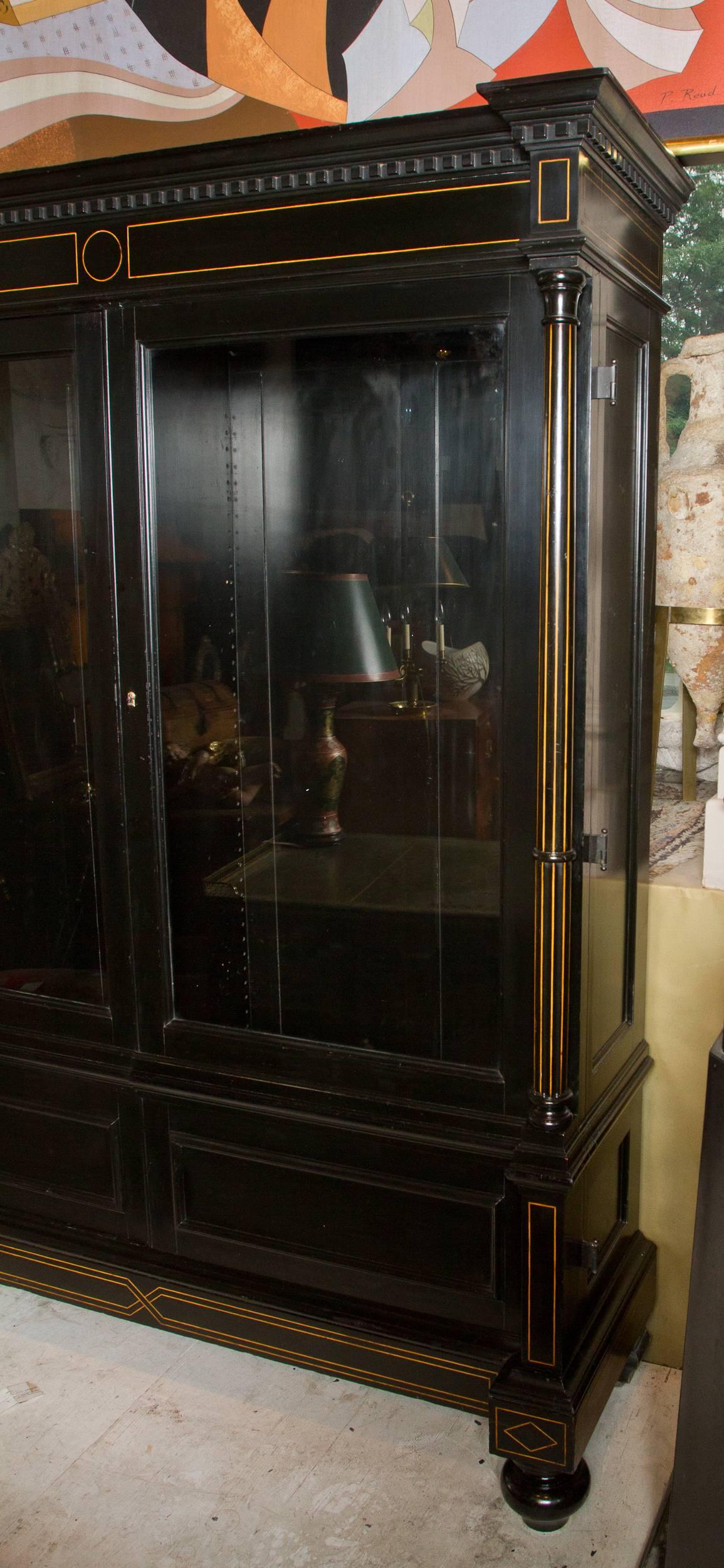 Stylish Napoleon III period ebonized bookcase decorated with boxwood string inlay, the two doors fitted glass panes.