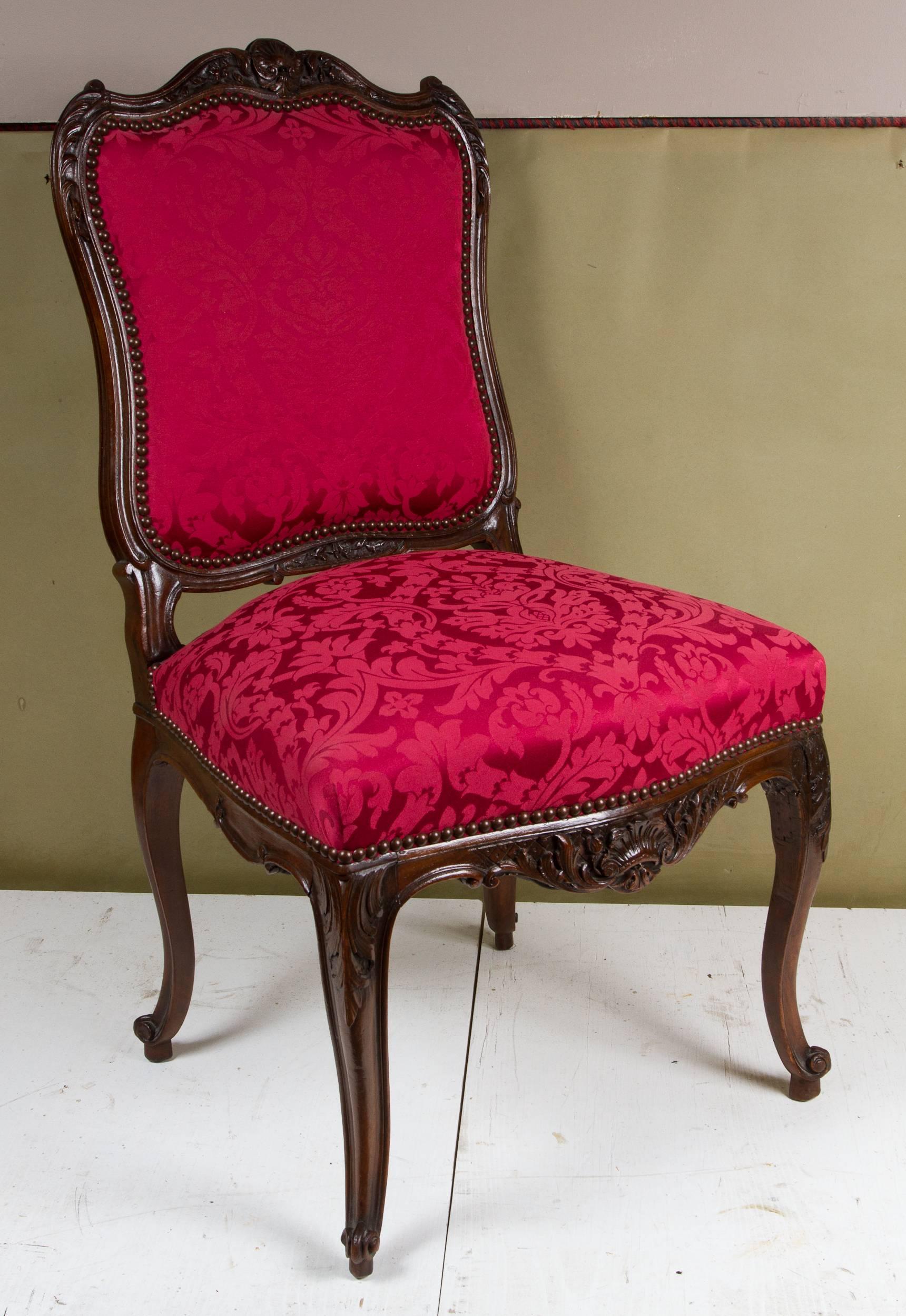 Set of four Louis XV style wooden carved chairs with crimson red brocart fabric.