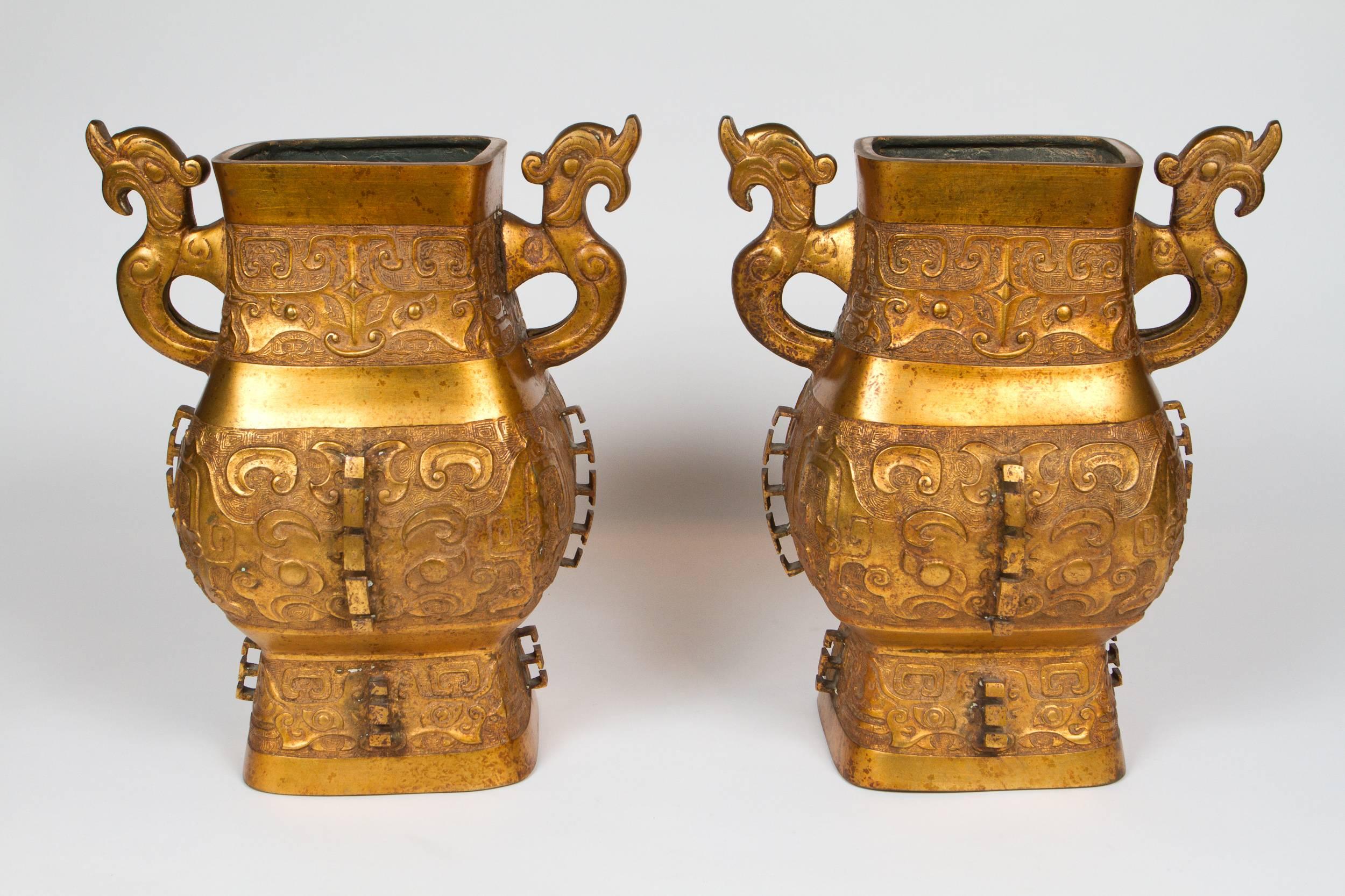Impressionnante paire de vases chinois archaïques en bronze doré. Parfaite échelle pour l'utilisation de lampes, déjà percées à cet effet.