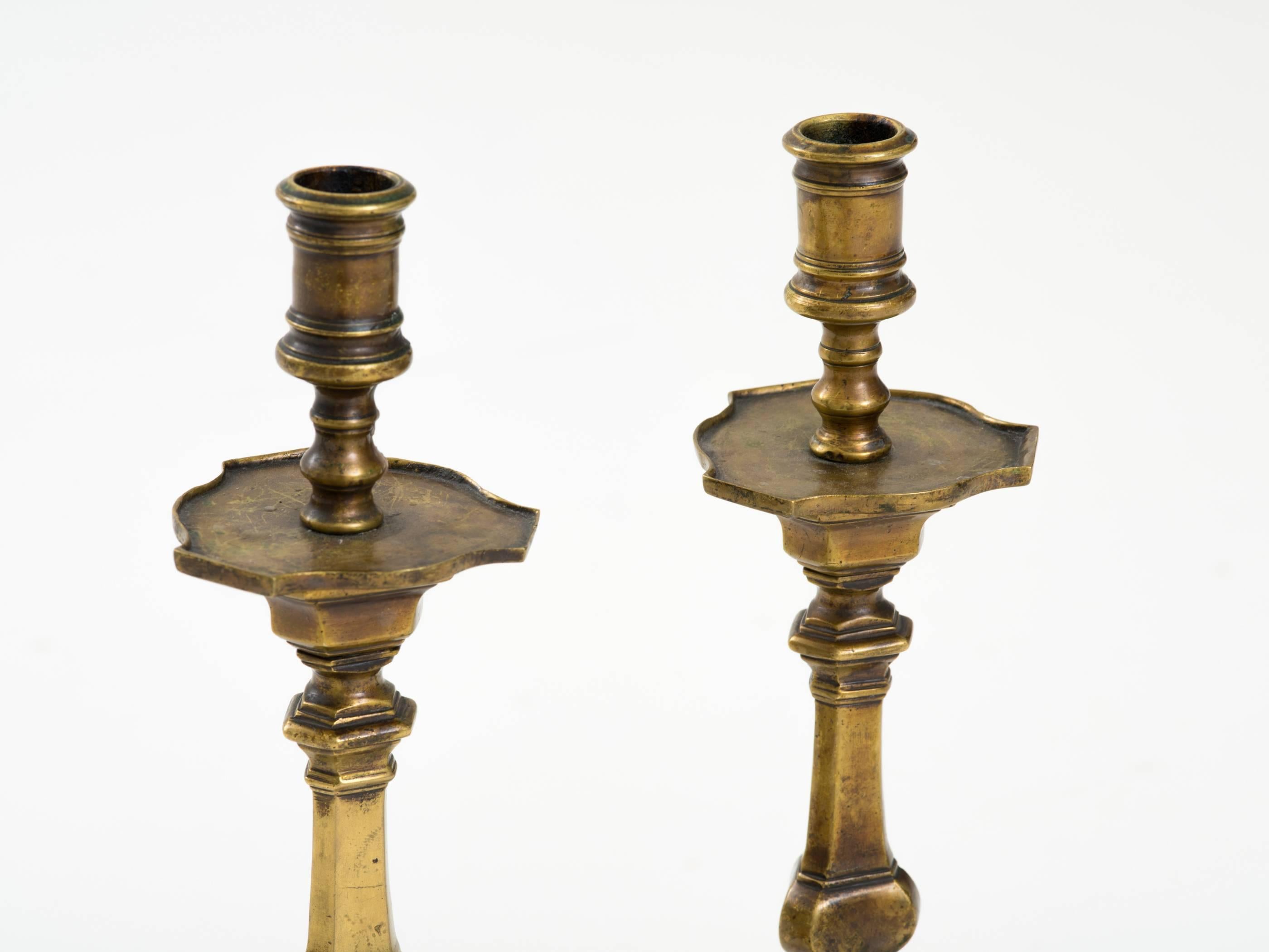 Pair of 18th century Spanish patinated bronze candlesticks on Baroque tripod bases.