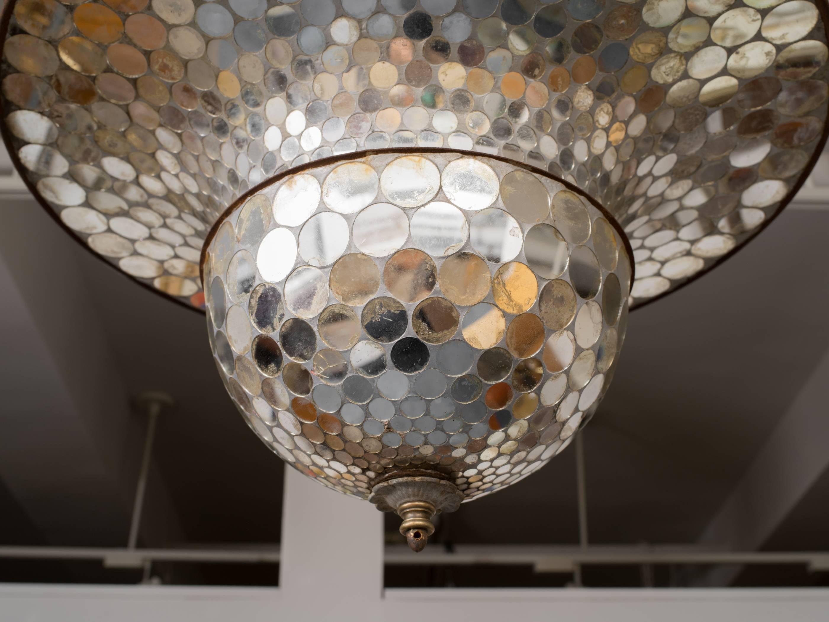 Whimsical mirrored mosaic suspension formally used as a disco ball it still has the electric motor that makes it revolve.
The interior newly fitted with light bulbs.