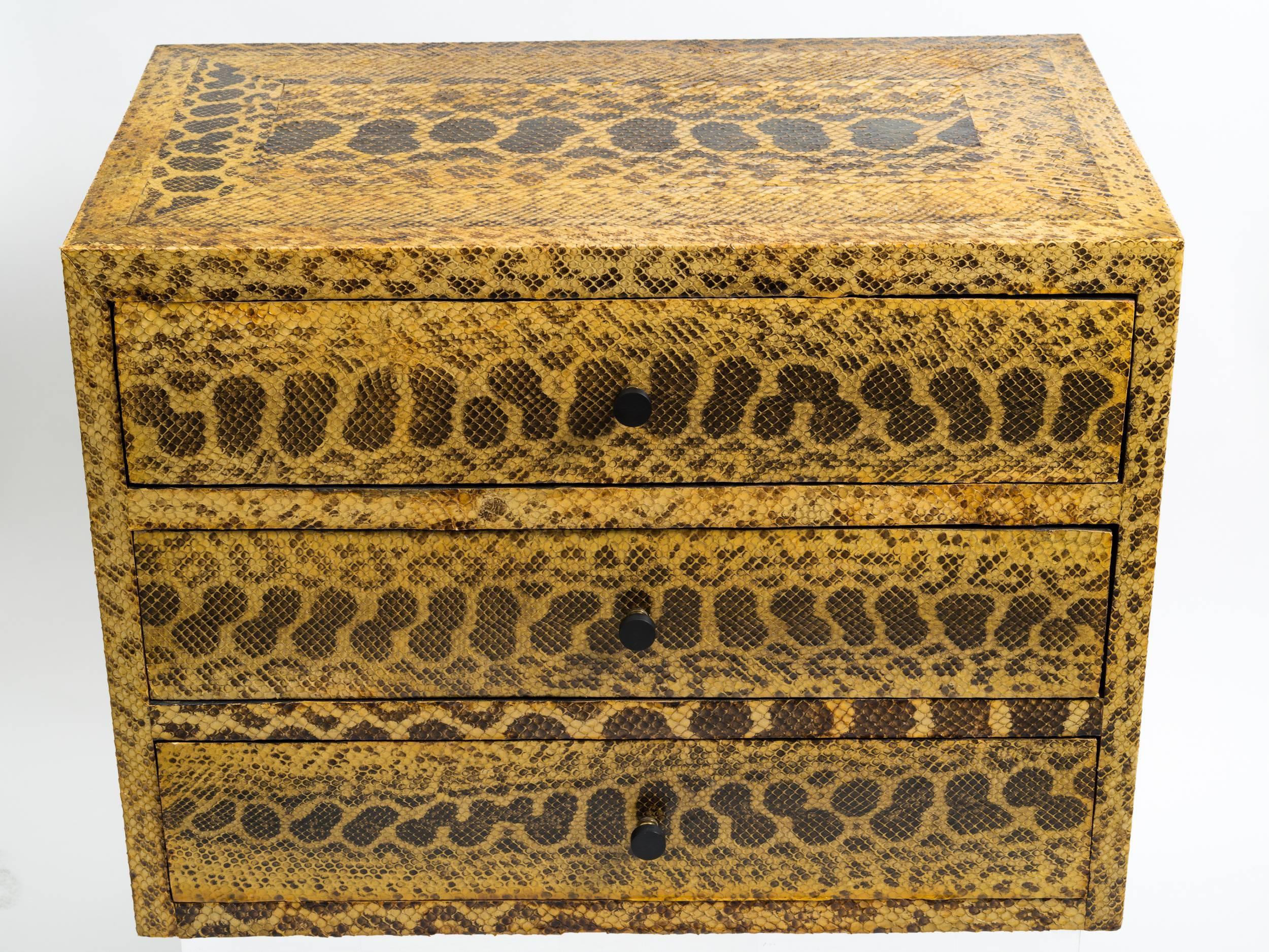 Python skin covered chest of drawers set on later silver leaf base. Provenance: Collection of Vincent Petragnani. Senior designer of Ethan Allen.