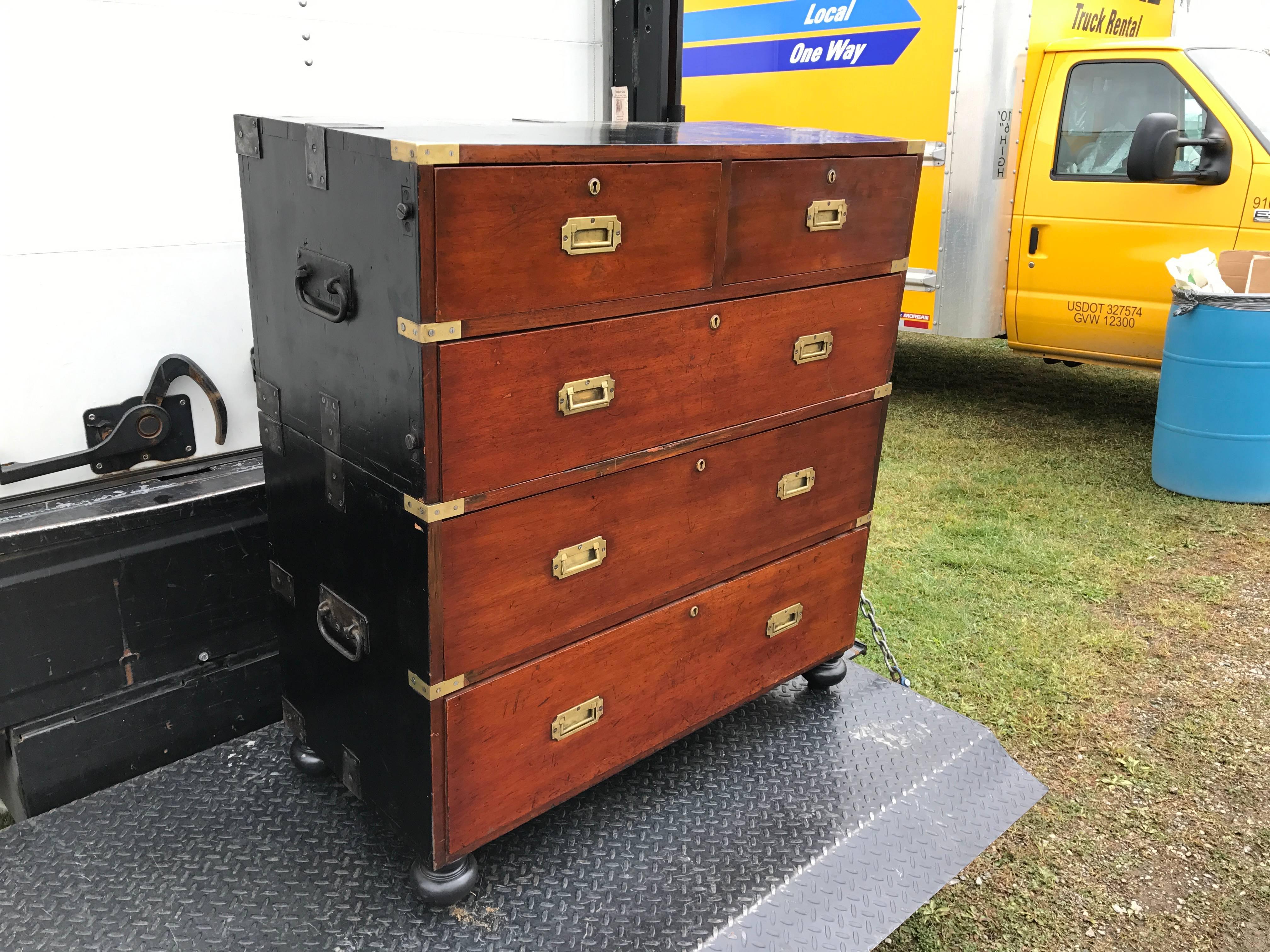 Great vintage mahogany and painted wood two-part campaign chest, the front fitted with typical flush mounted brass hardware, the top and sides fitted with unusual steel reinforcement and fittings for traveling use.
This is a true campaign chest