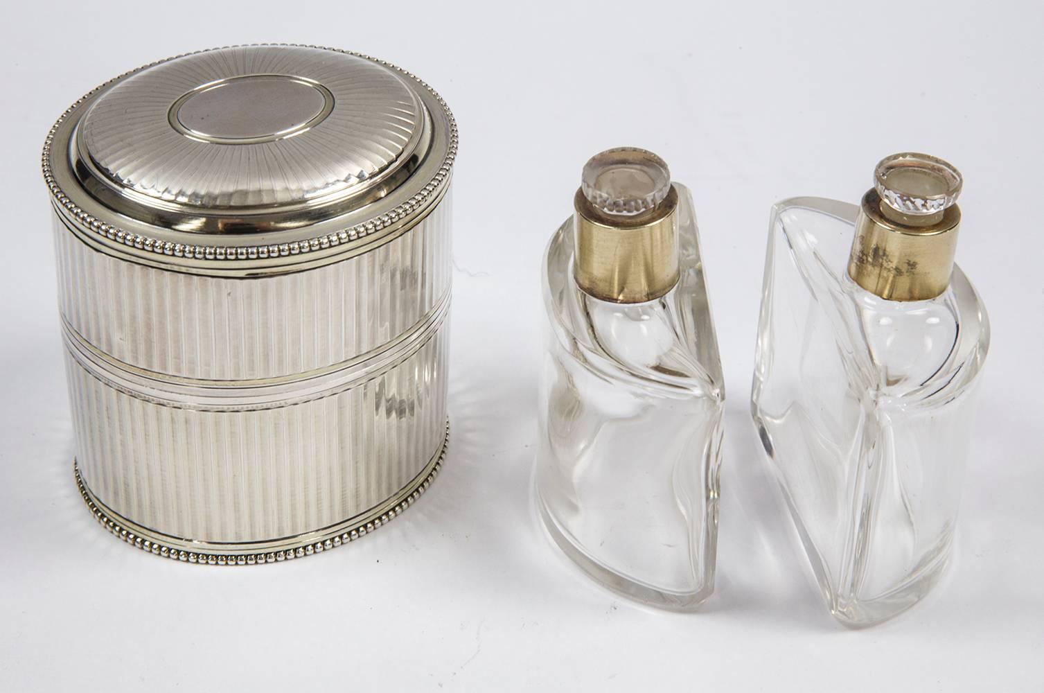 Antique French sterling silver oval shaped perfume bottle holder set, complete including two empty fitted demilune glass bottles with fitted sterling silver collars and stoppers. Approximately size: 2.75” x 2.5” x 3” high.
     