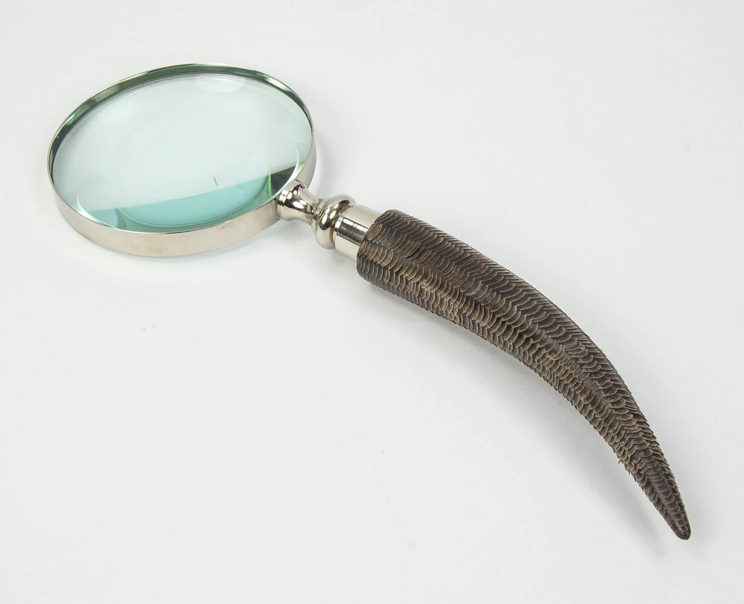 Featuring a curved celluloid handle with applied fish scale pattern magnifier; approximate 11.25” long; chrome rimmed magnifying glass measures approximate 4” in diameter; Modernistic, Avant-garde and functional. A perfect gift for that special