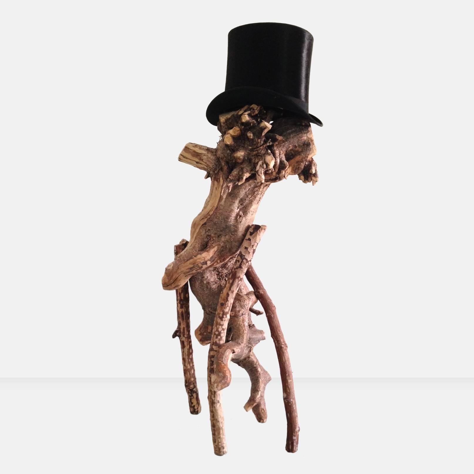 Main body hand-carved reclaimed tree root with carved maple and rosewood branches Sculpture with top hat (circa 1900) resting on top of the sculpture; hand-carved (without hat); Andrew Plum’s abstract wood sculpture, impression of the famous rock