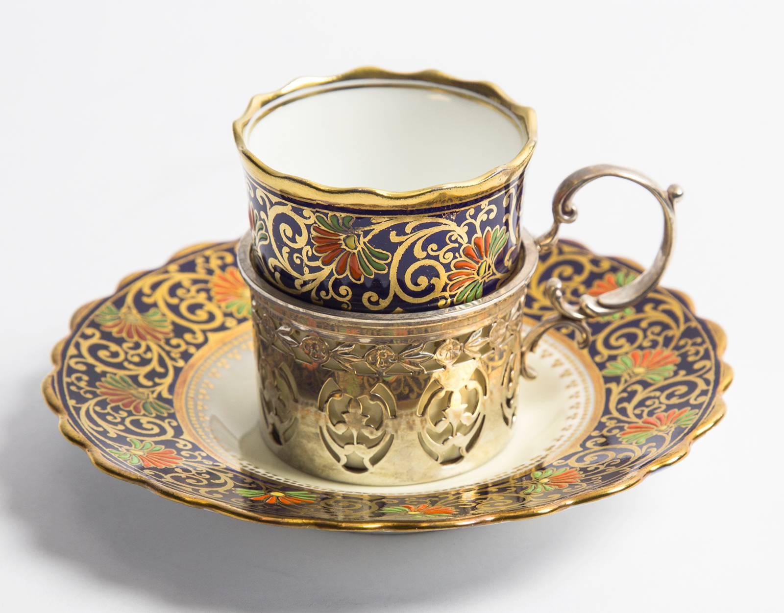 Beautiful Demitasse set, comprising eight Birks sterling silver cup holders with eight Aynsley, England bone china porcelain cup inserts and eight saucers. Each piece is encompassed by coral and green floral designs on cobalt blue ground, enhanced