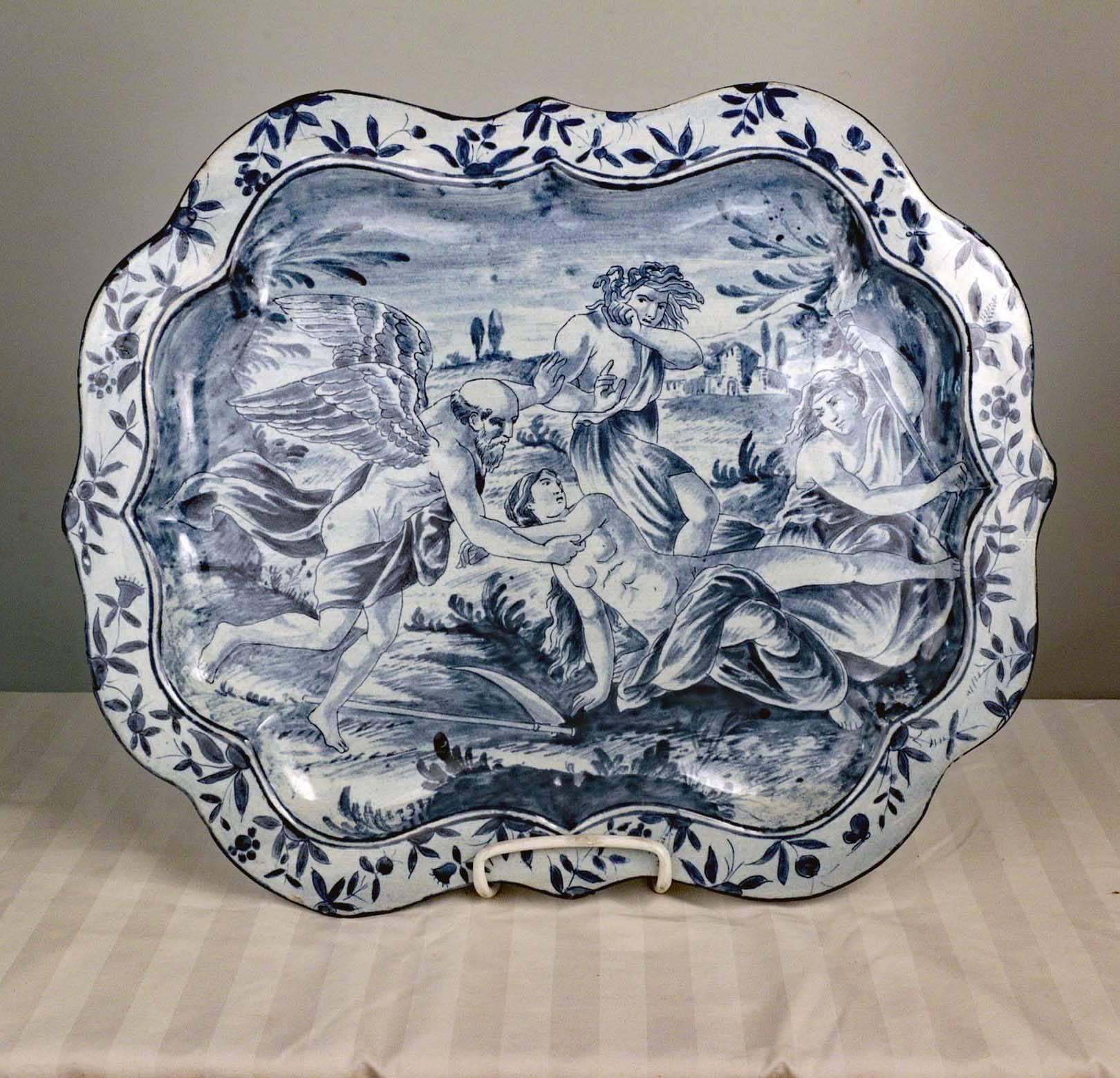 Antique pair of Savona Majolica serving dishes.  Painted in blue, one depicts a satyr, putti and two young girls, all enjoying the new wine: the other is painted with an allegory of time.
These charming meat plates were destined to be hung. They
