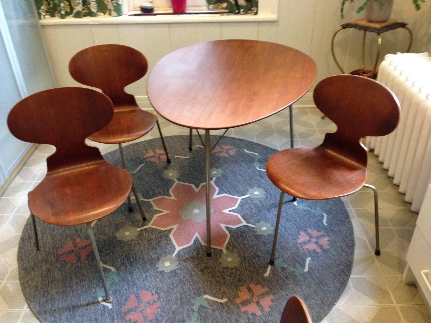 Mid -Century iconic Danish teak Egg table and teak Ant chairs by Arne Jacobsen.  Made by Fritz Hansen, the table with maker’s partial logo on the underside, the chairs with the logo stamped to the underside of the metal frame of the seat.

Formed