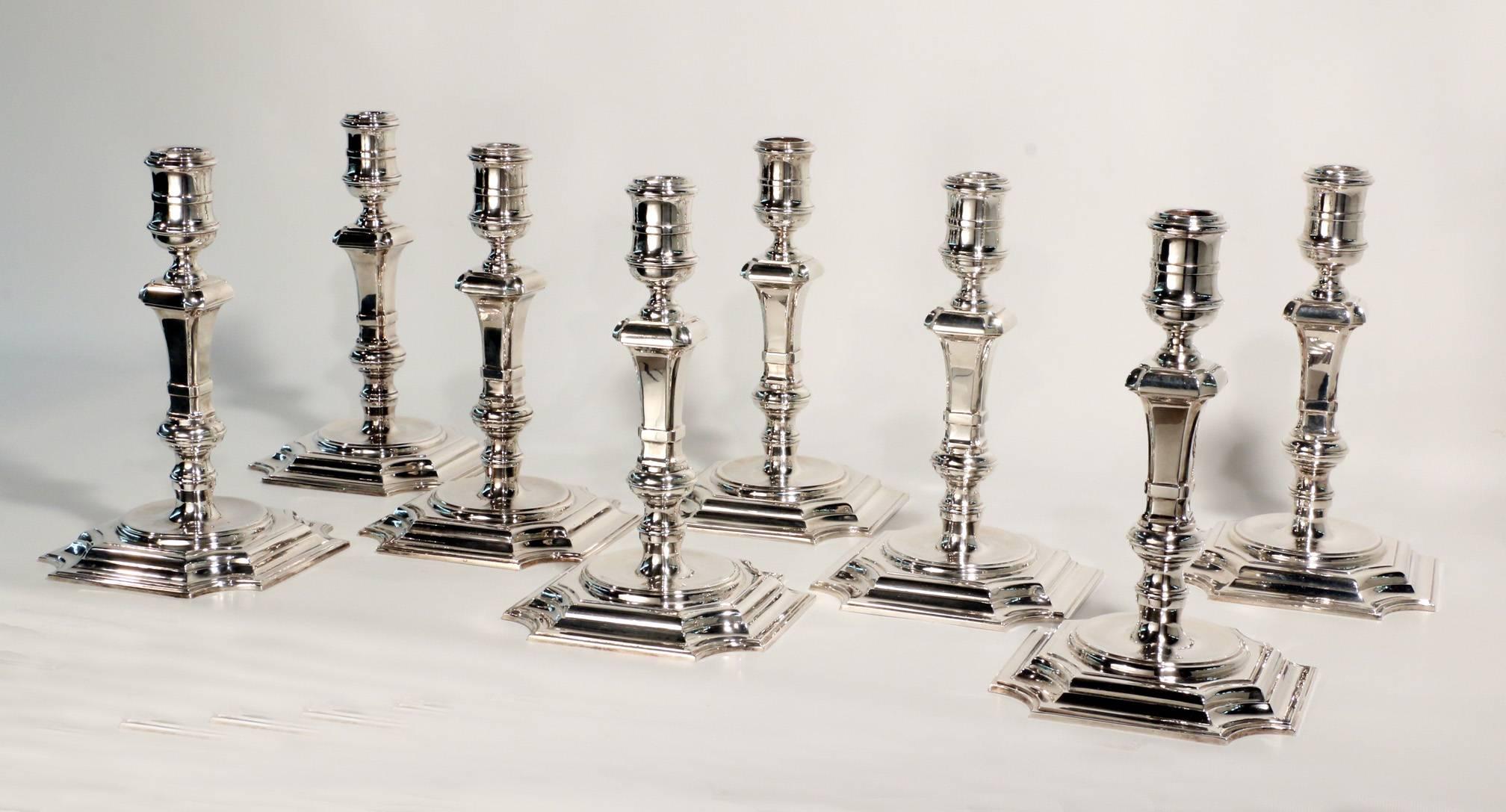 A superb suite of  8 George II style  Hall Marked Silver cast candlesticks of unusual size and very substantial gauge,, each with baluster stem and on square cut-corner base, comprising:
A pair of 5 light candelabra ...London, 1979...15.5 ins