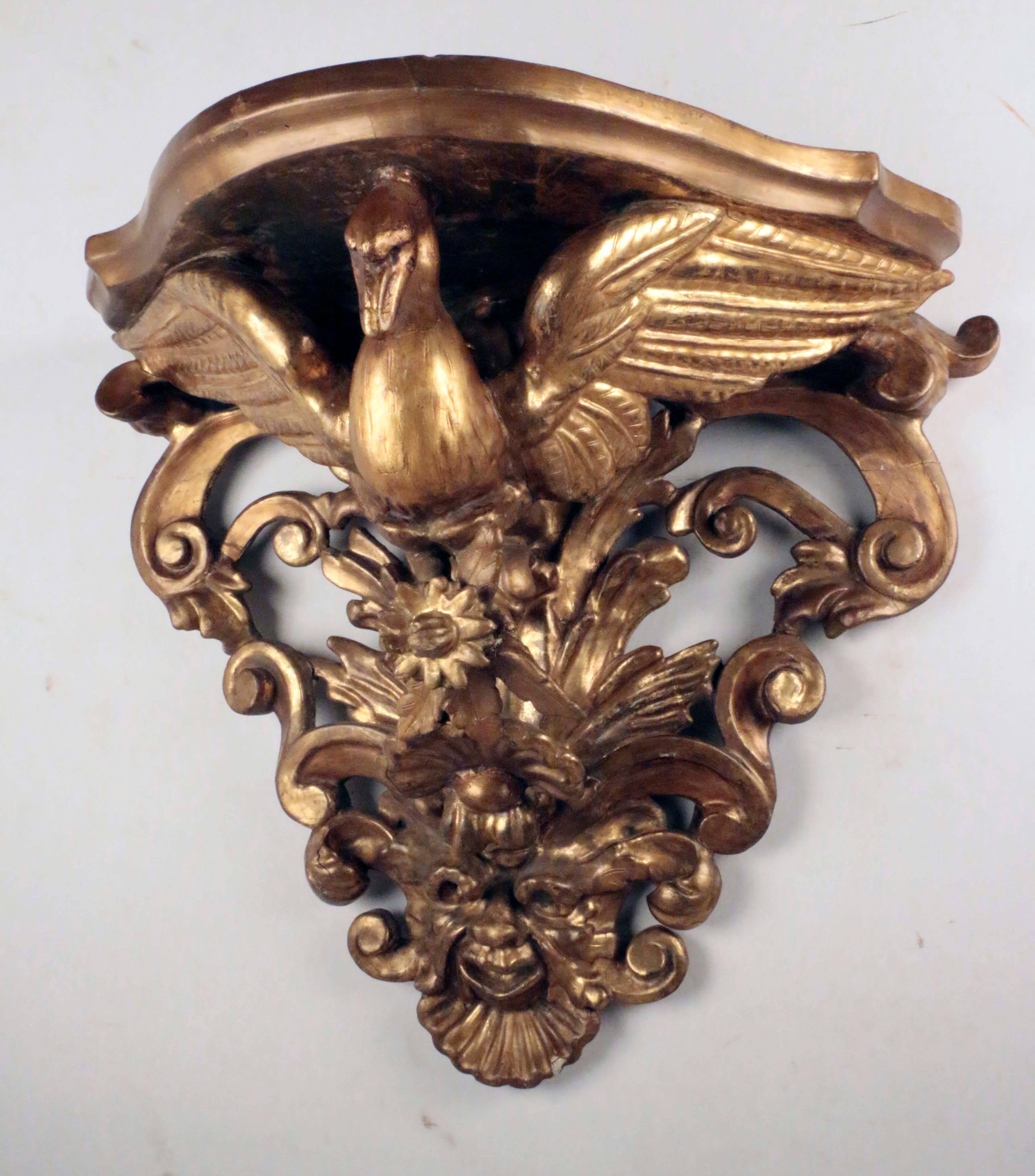 Pair of Italian giltwood wall brackets, each shelf supported by
a Ho Ho bird feeding on grapes  against an acanthus leaf background. 
