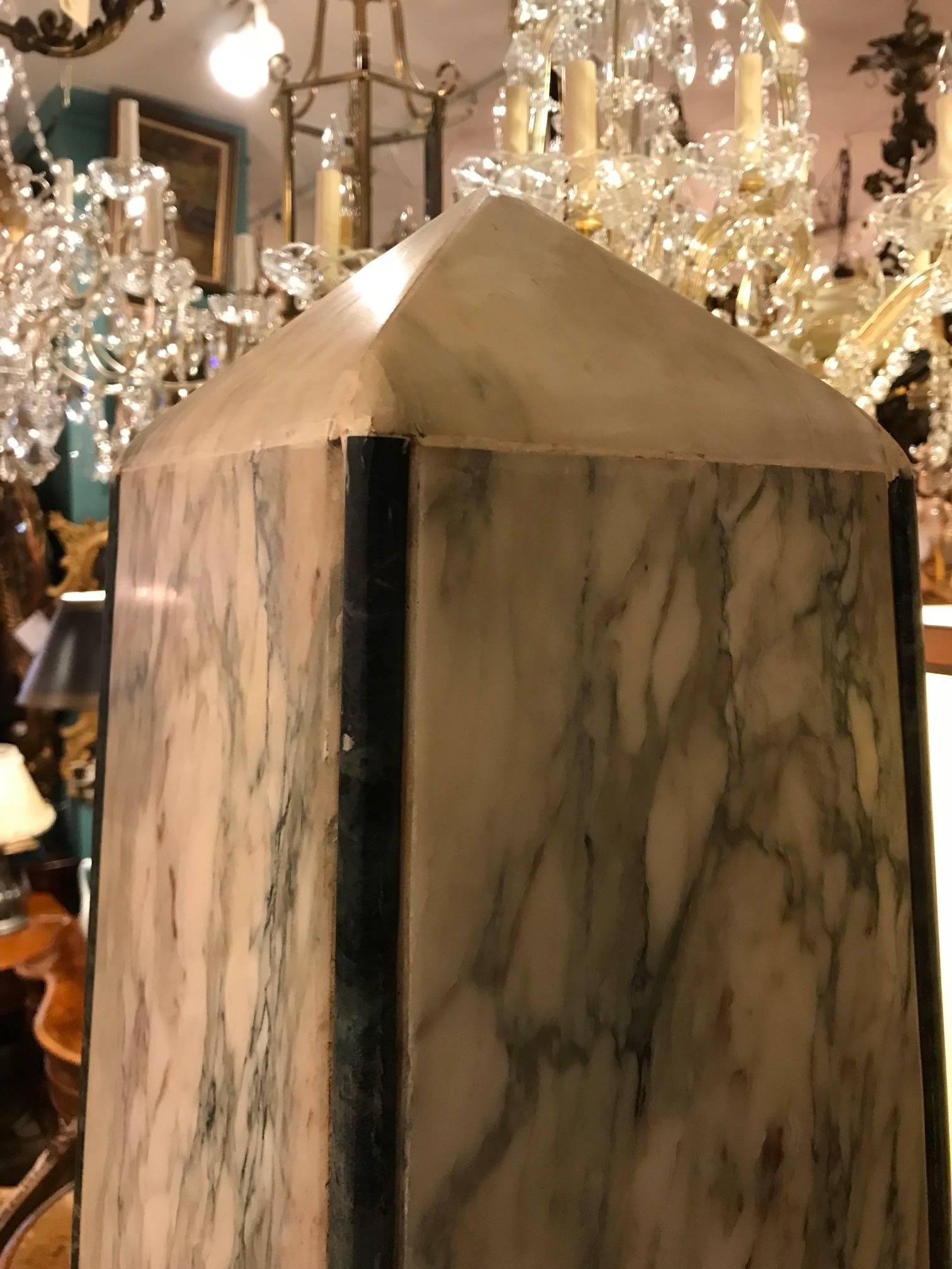 Pair of veined white marble garden obelisks with  contrasting dark green marble moldings, on square stepped plinths with lozenge shaped appliques.

Obelisks and all things Egyptian come into fashion after Napoleon's unfortunate campaign in Egypt.