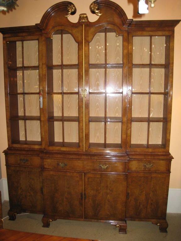 George II style  breakfront bookcase,the upper section with arched and broken pediment, the lower enclosed by cupboard doors. This is unusually small and also unusual to find in this figured walnut. with gilt high-lights.