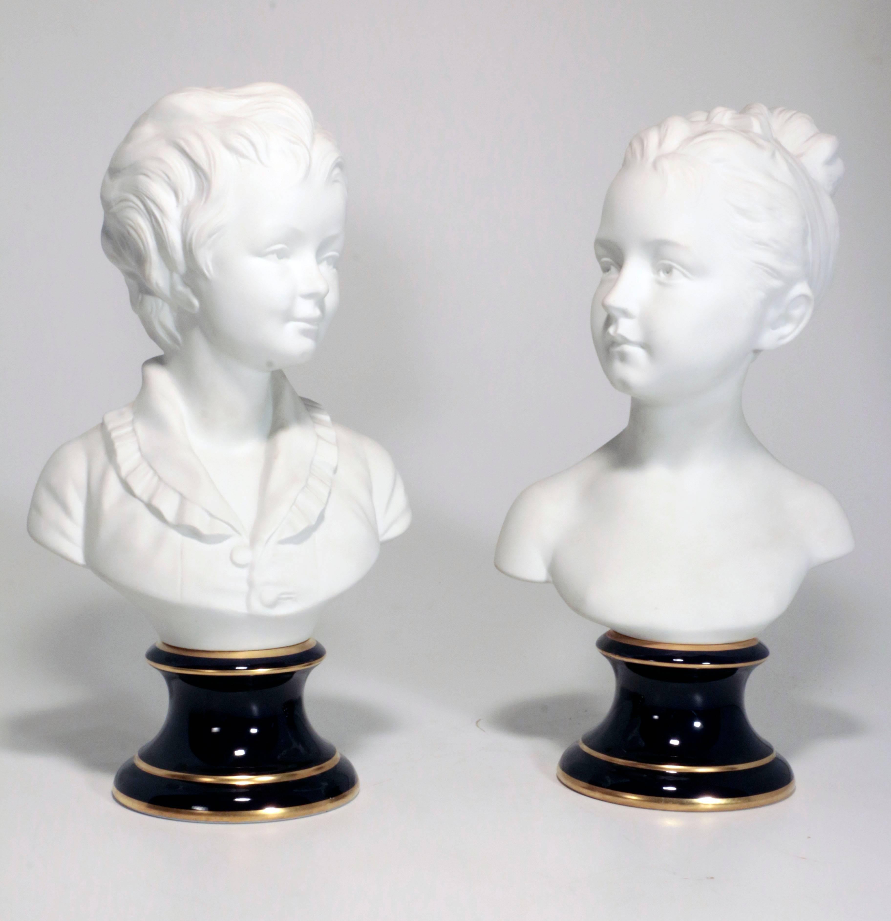 Pair of busts of Louise and Alexandre Brogniart in bisque porcelain on royal blue enameled base, by Tharaud, Limoges, after the originals by Jean-Antoine Houdon (1741-1828.)
