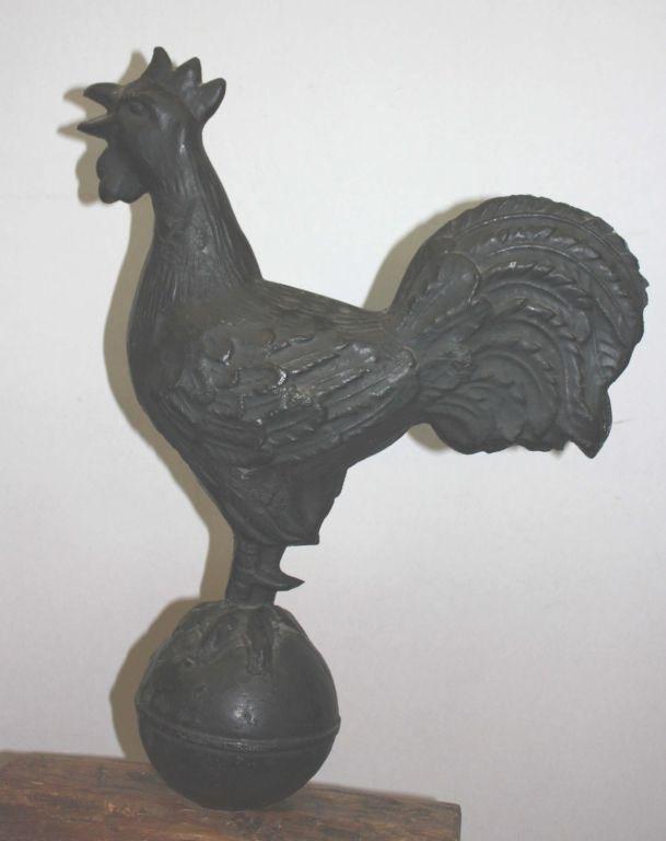 Cast iron ornament (formerly a windmill weight) as rooster on wooden base.