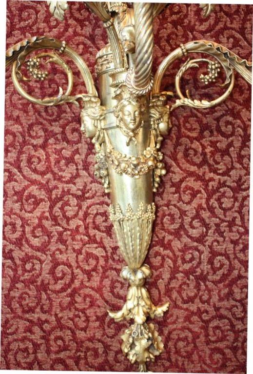 A Superb Pair of Massive Second Empire Gilt Bronze five light  wall sconces, in the Louis XVl  taste, each vase- shaped body applied with masks and garlands, the scrolling arms are ribbed and the drip pans are spiral fluted,  later electrified,