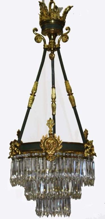Kronleuchter aus grün emaillierter und vergoldeter Bronze aus der Zeit Napoleons III. Der Ring aus Band und Maske ist an drei Stäben an der Palmetto-Krone aufgehängt und mit drei abgestuften Schichten von Prismen drapiert. Später an die Elektrizität