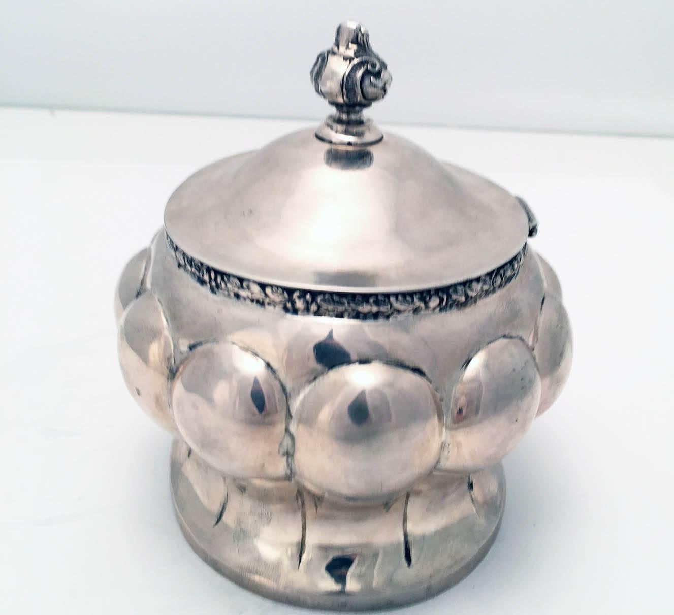 Scatola per zucchero o etrog austriaca secessionista di forma ovale lobata, con corpo a vita e coperchio ovale a cupola con cerniera, applicato con un finale a forma di urna, con interno dorato.