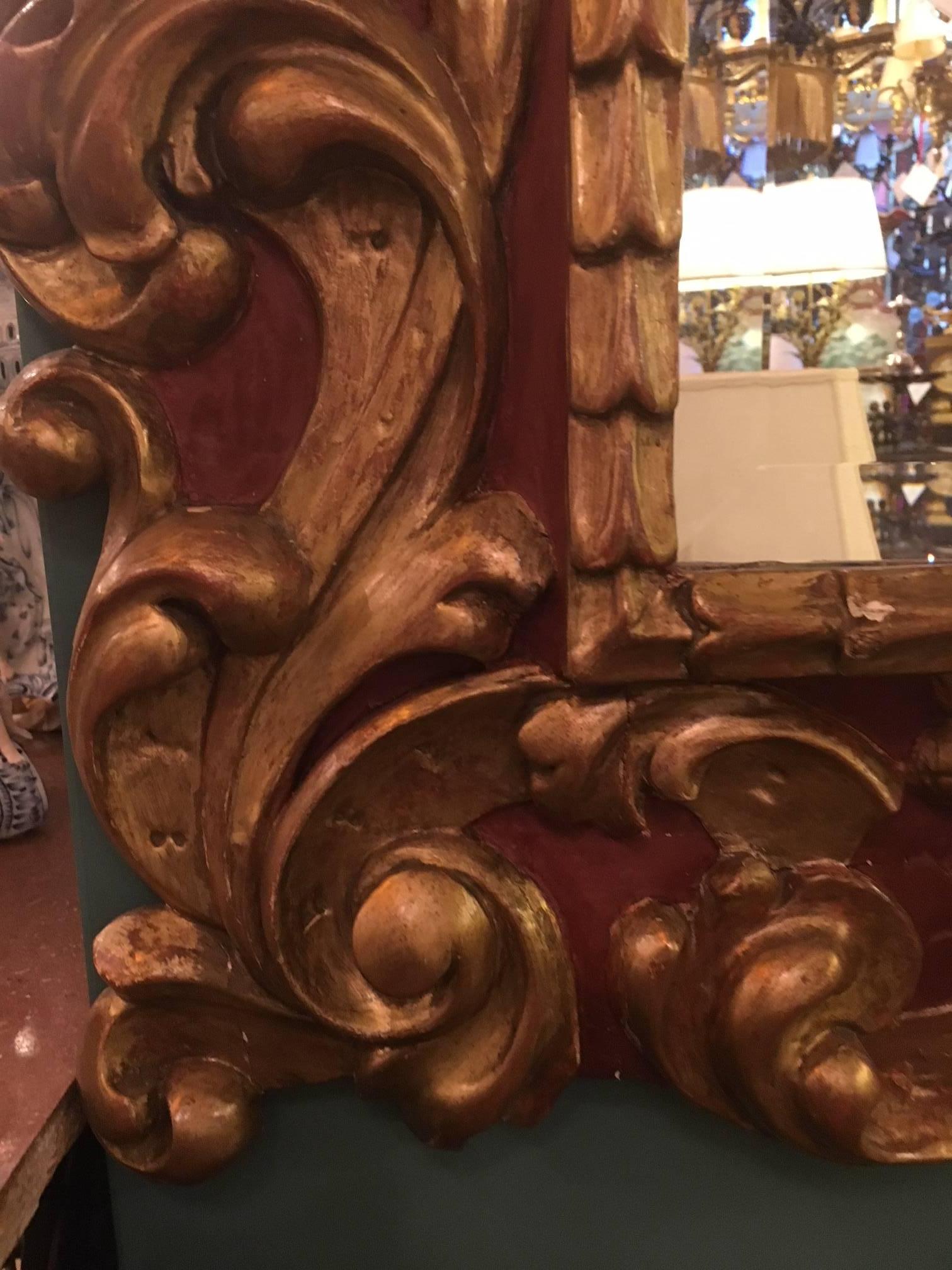 Bois Miroir de style baroque,  Le cadre est sculpté, peint et doré  en vente