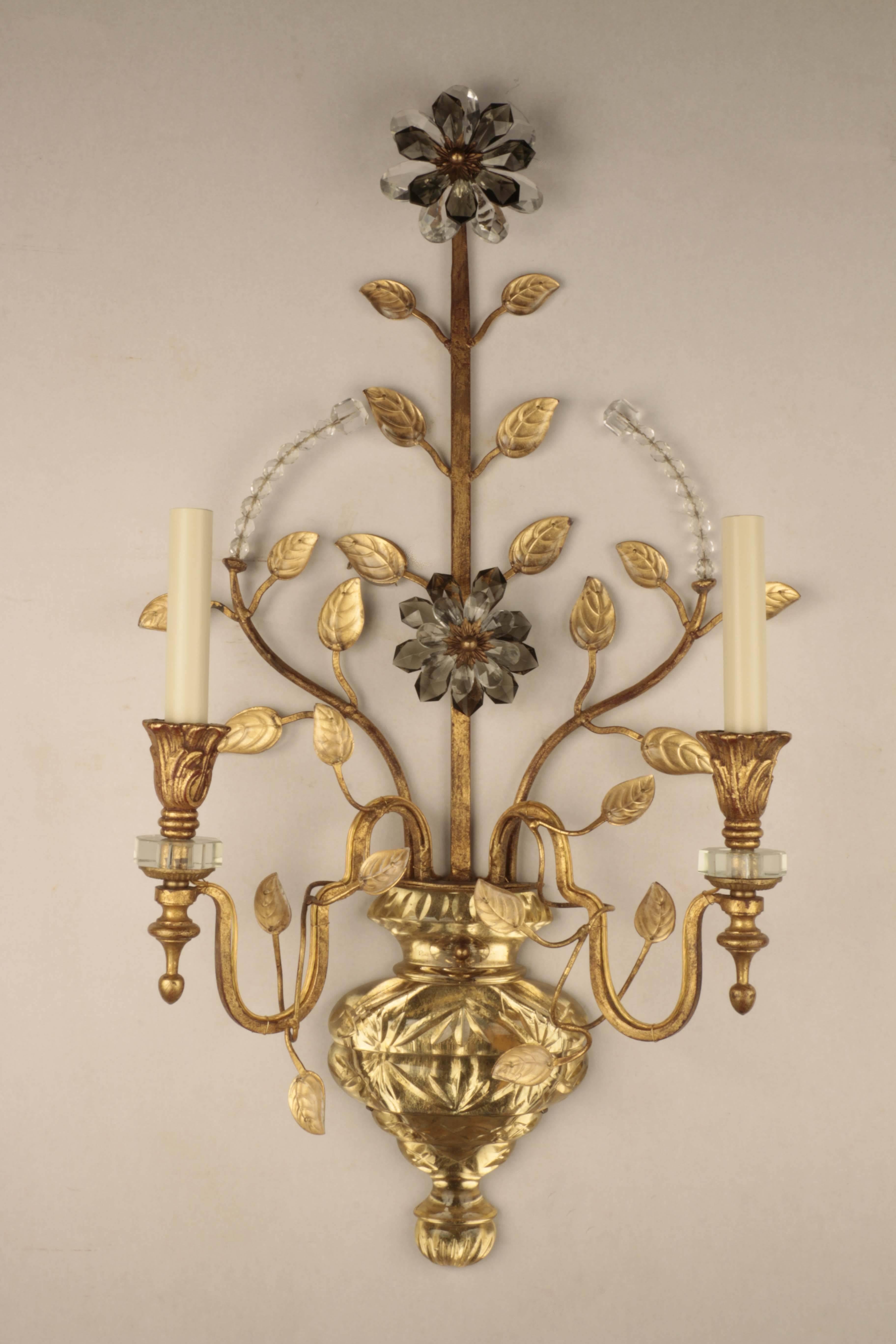 Pair of large Baques two-light wall sconces each modelled as a cut vase from which stylised leaves and flowers emit, subtle gilt backing creates a pleasing contrast of color and light. The combination of giilded metal, cut rock crystal and backing