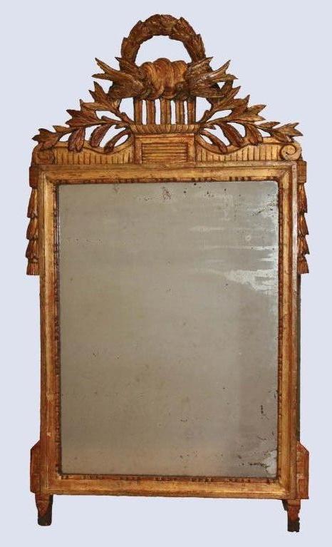 Louis XVI period carved and giltwood wall mirror, the pediment of doves of peace fronting a laurel wreath; the sides with trailing bellflowers.