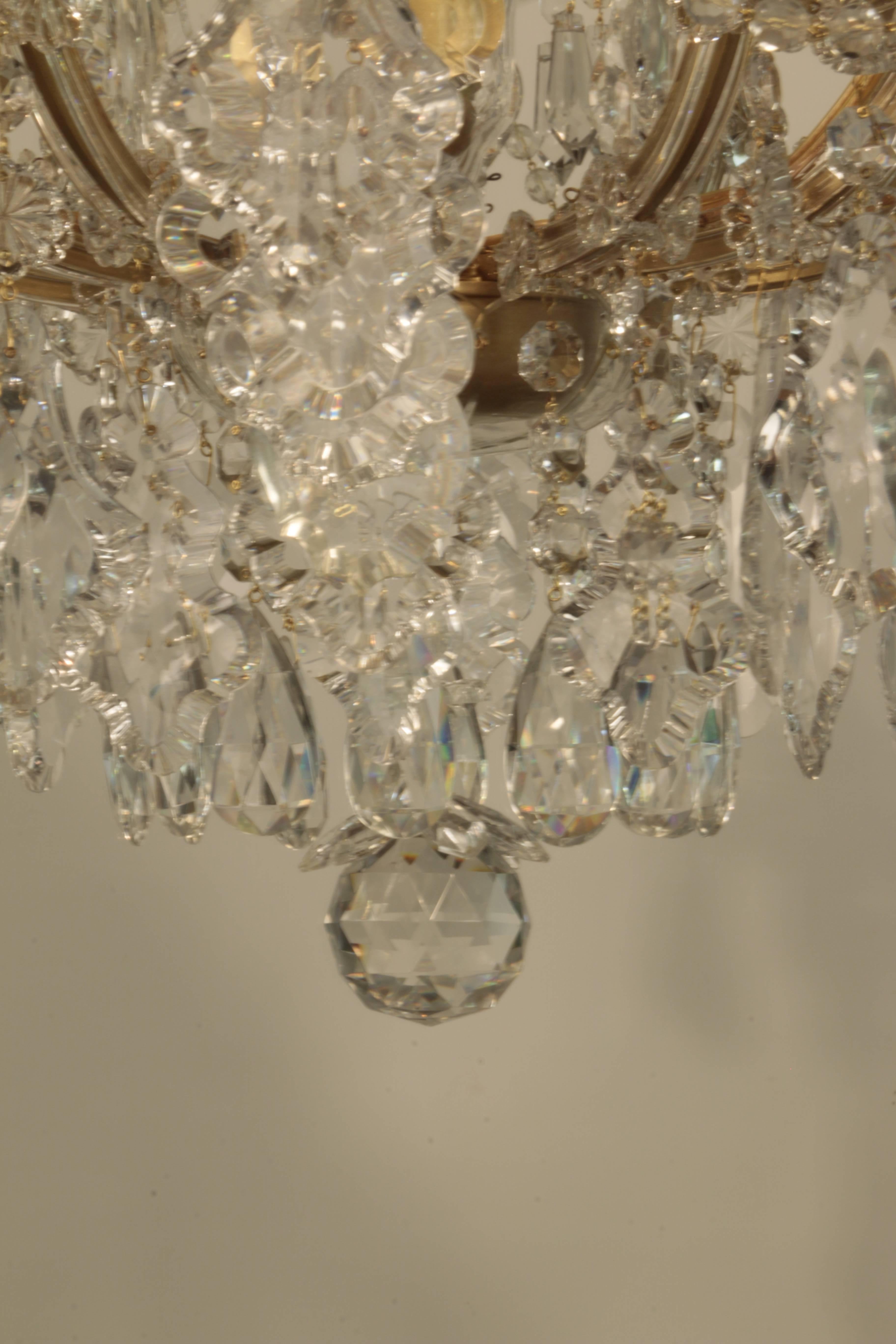 An unusually large vintage Czechoslovakian Marie-Therese cut crystal chandelier. The upper tier with 6 lights, the lower tier 12, the whole profusely hung with drops, hanging beads and French style pendaloques crystals.
Unusually, this wonderful