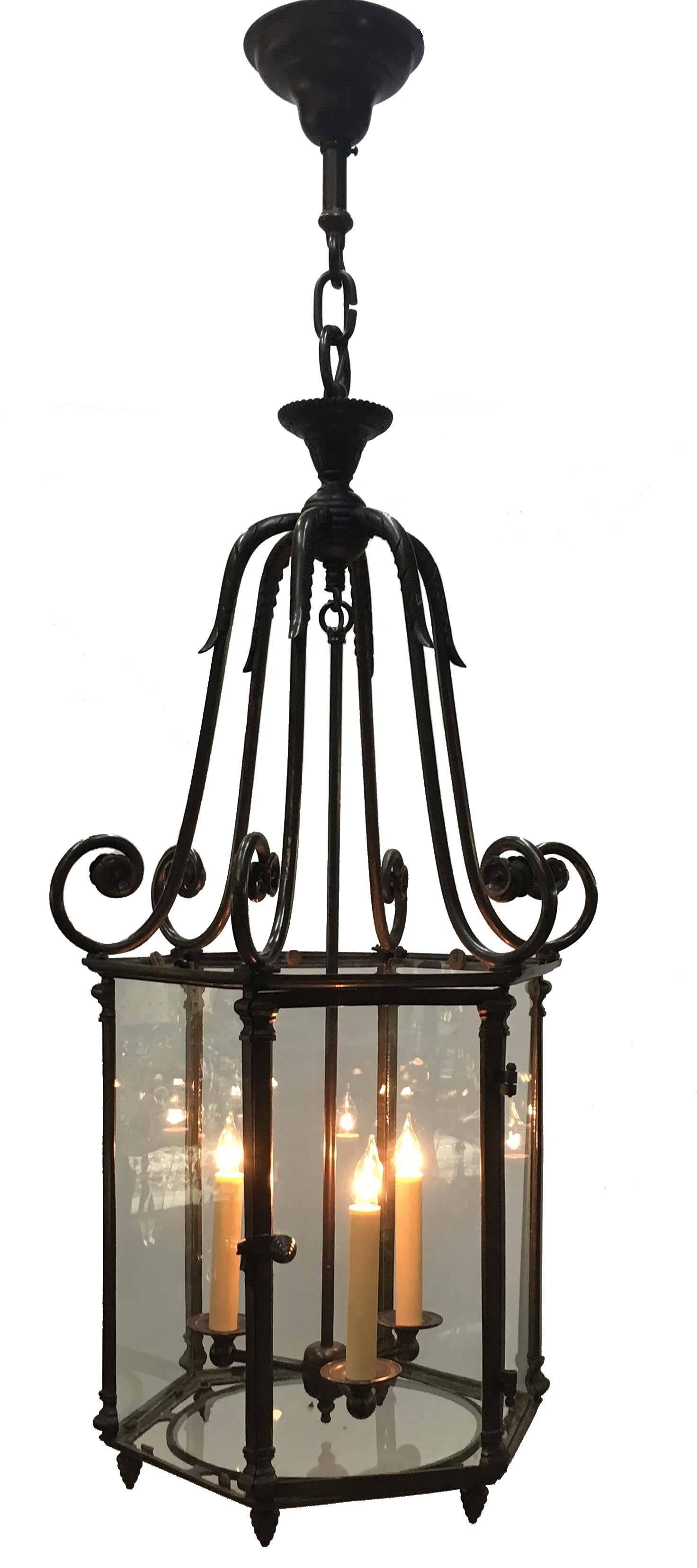 An antique Louis XV style brass hexagonal  lantern, supported by six scrolling arms later fitted for electricity with a three-light cluster. This was originally a gas fixture.
